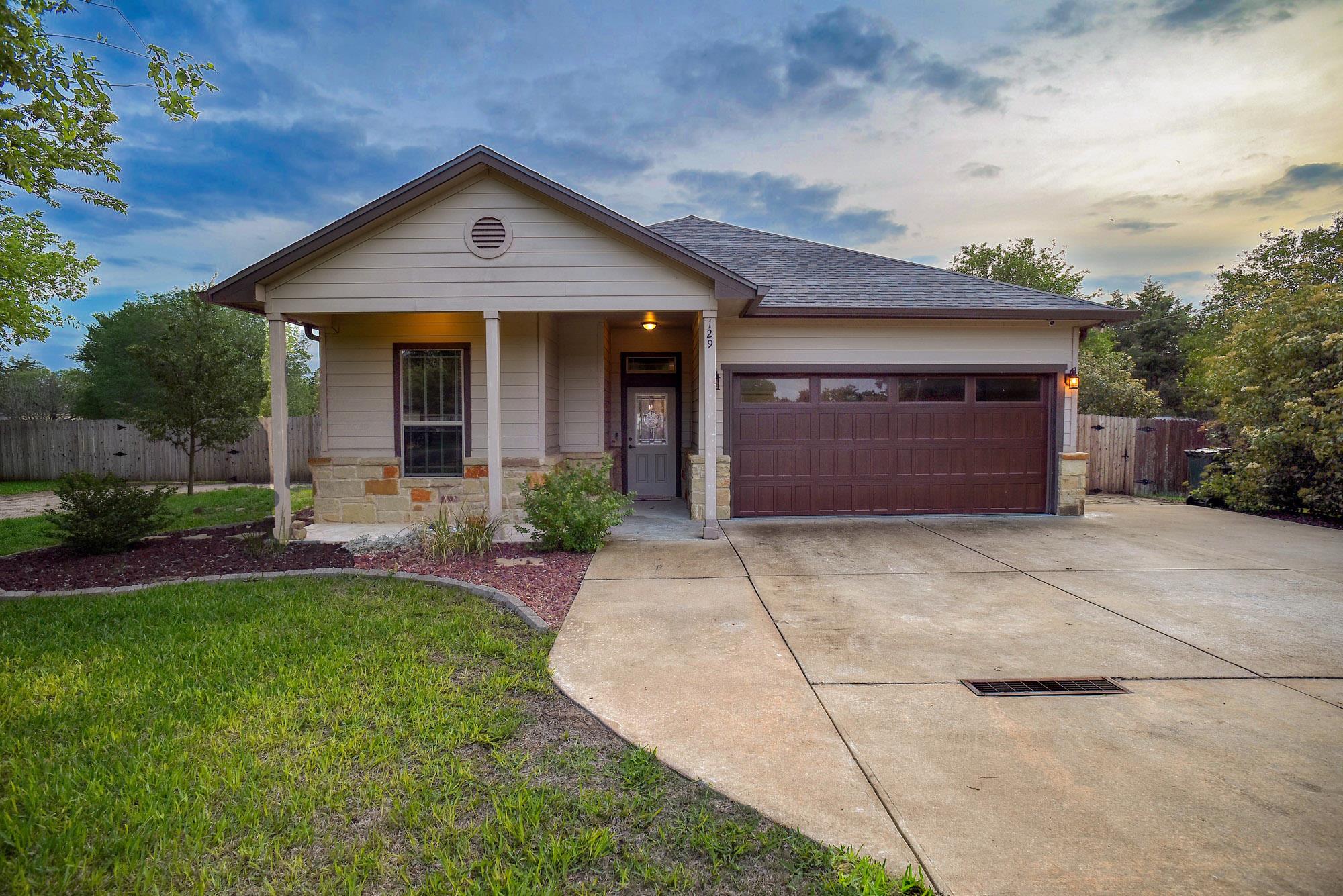 The property features a front lawn, a concrete dr