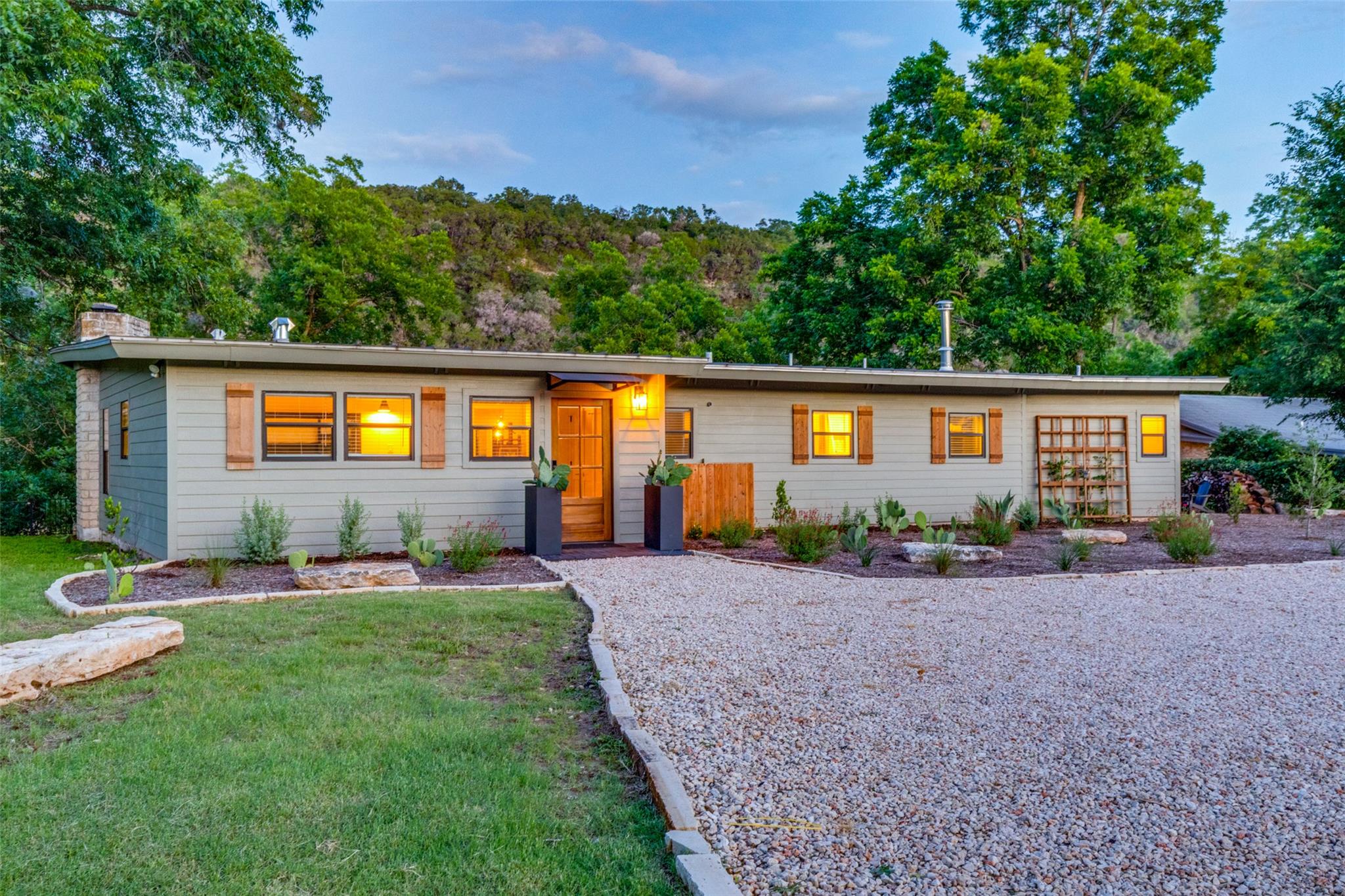 A charming exterior with a gravel driveway, wood 