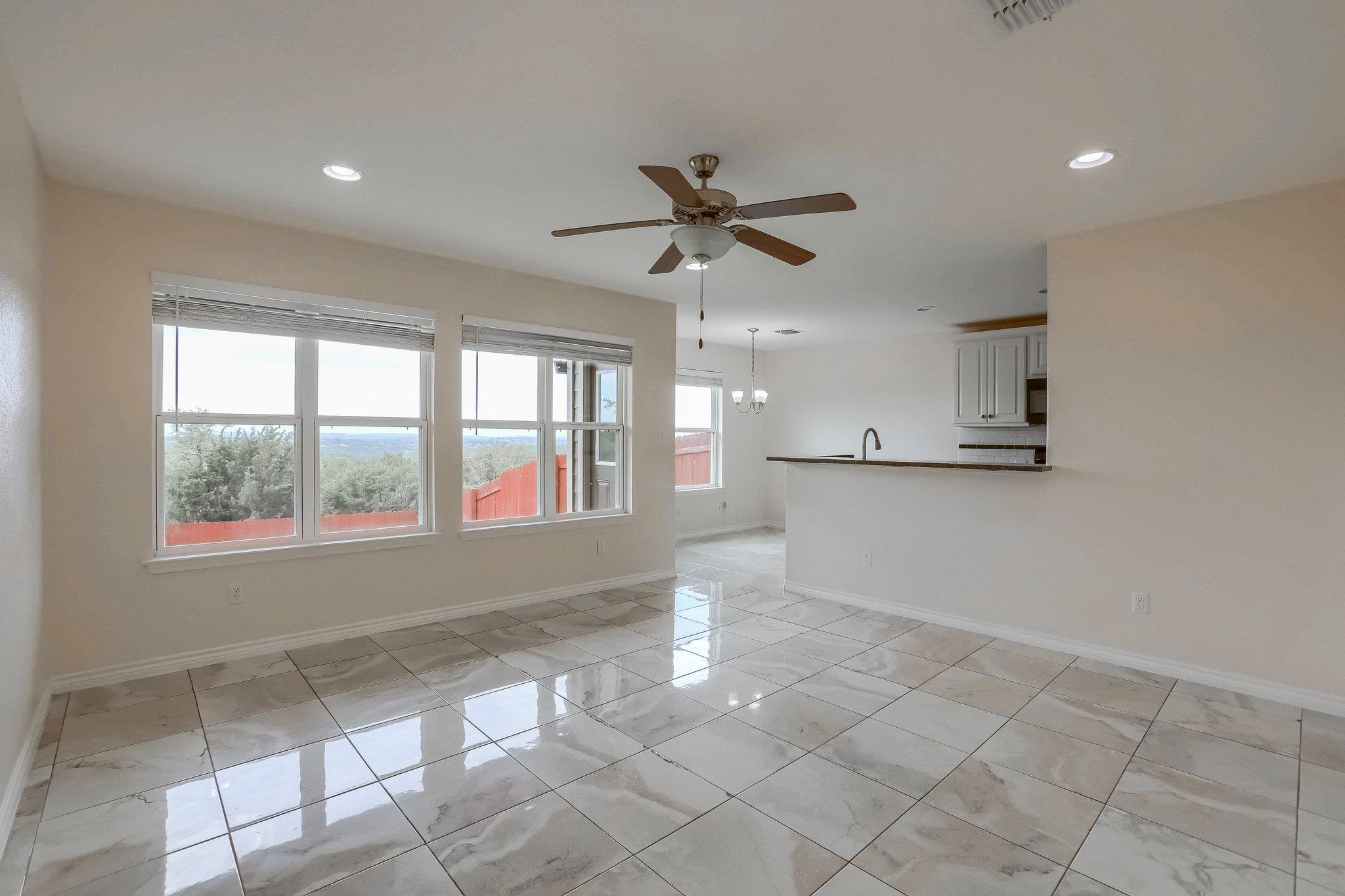 Spacious living area featuring large windows, til