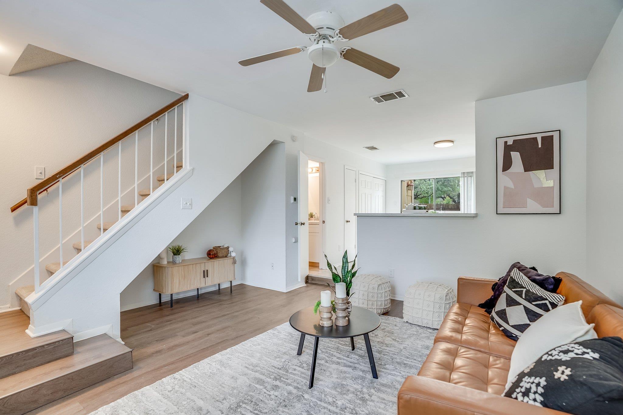 The living area features wood-look flooring, a st