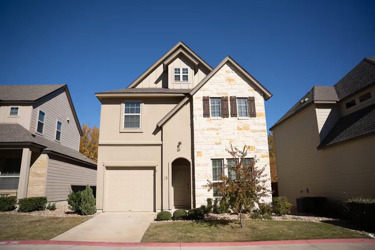 Two-story residence featuring a mixed facade of l