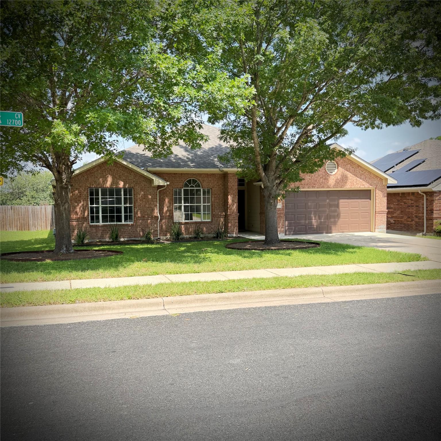 Mature shade trees frame a classic single-story b