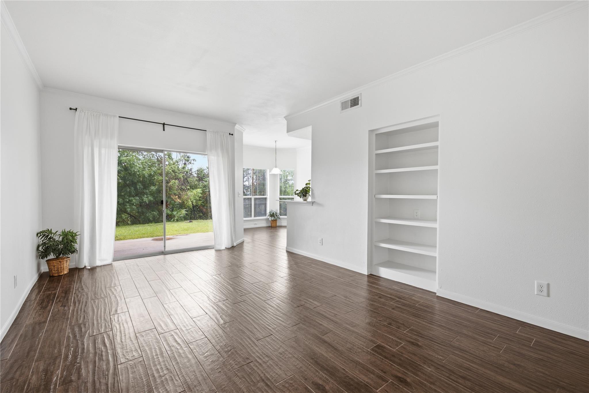 Floor-to-ceiling glass sliding doors open to gree