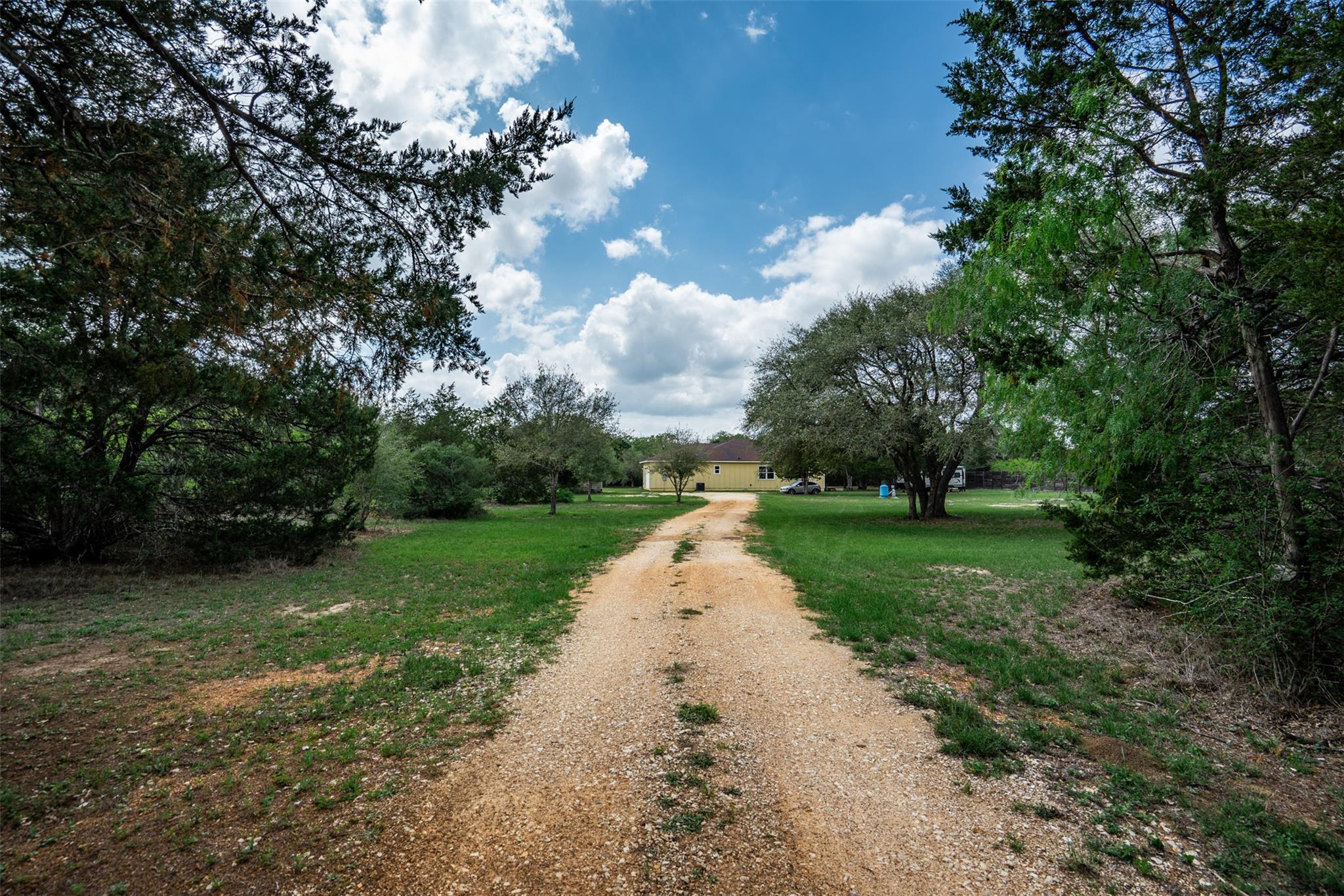 The property features a gravel driveway leading t