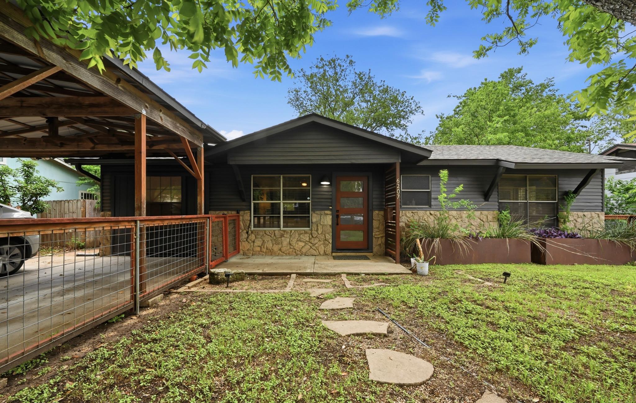 Exterior facade featuring dark siding, stone vene