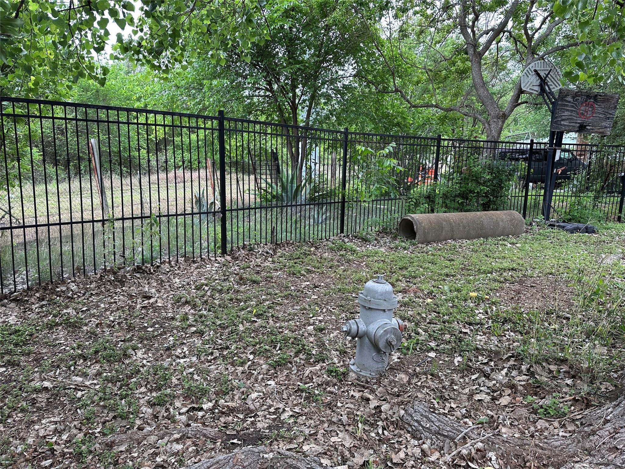 Black metal fencing bordering a natural landscape