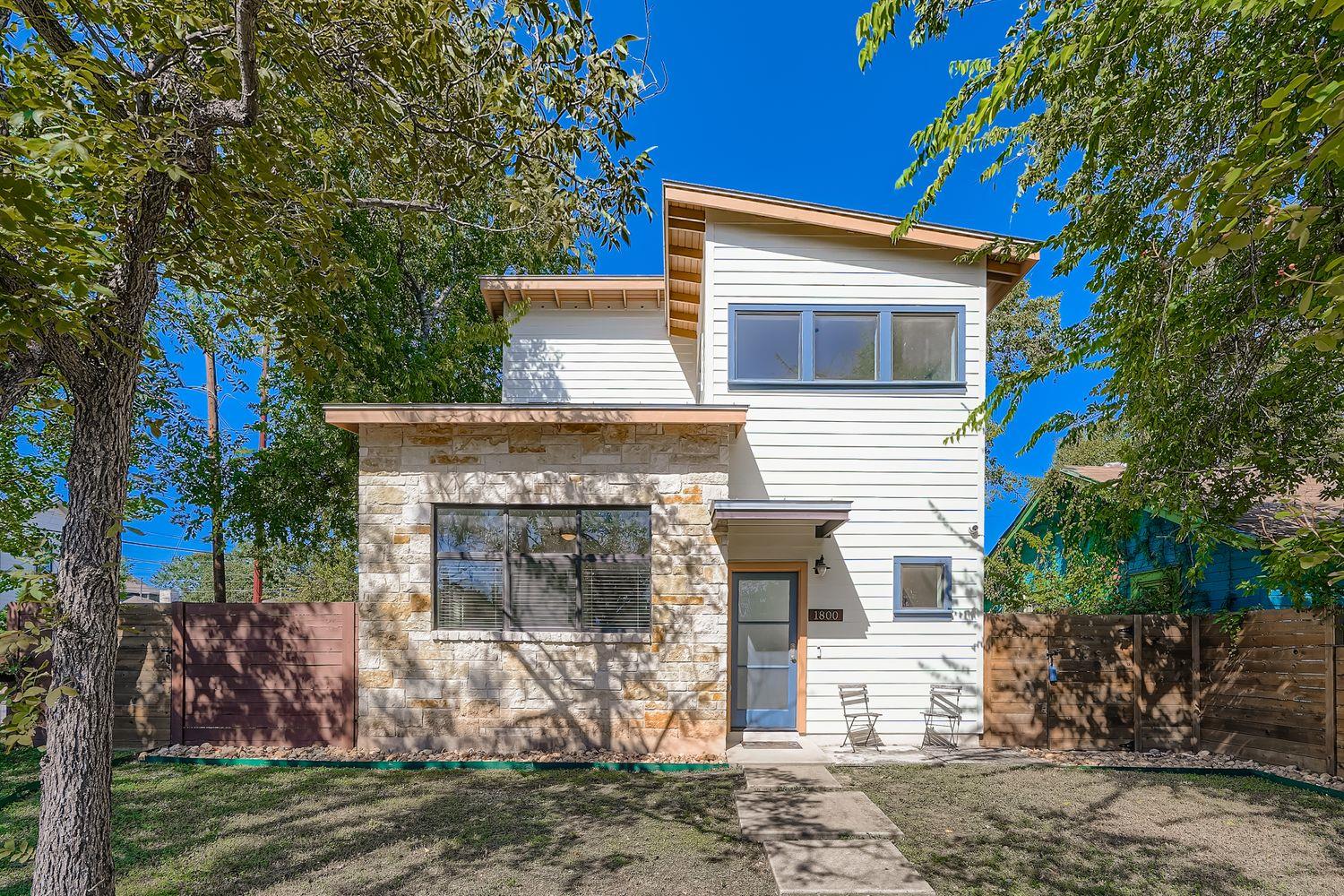 Two-story modern dwelling featuring a stone and h