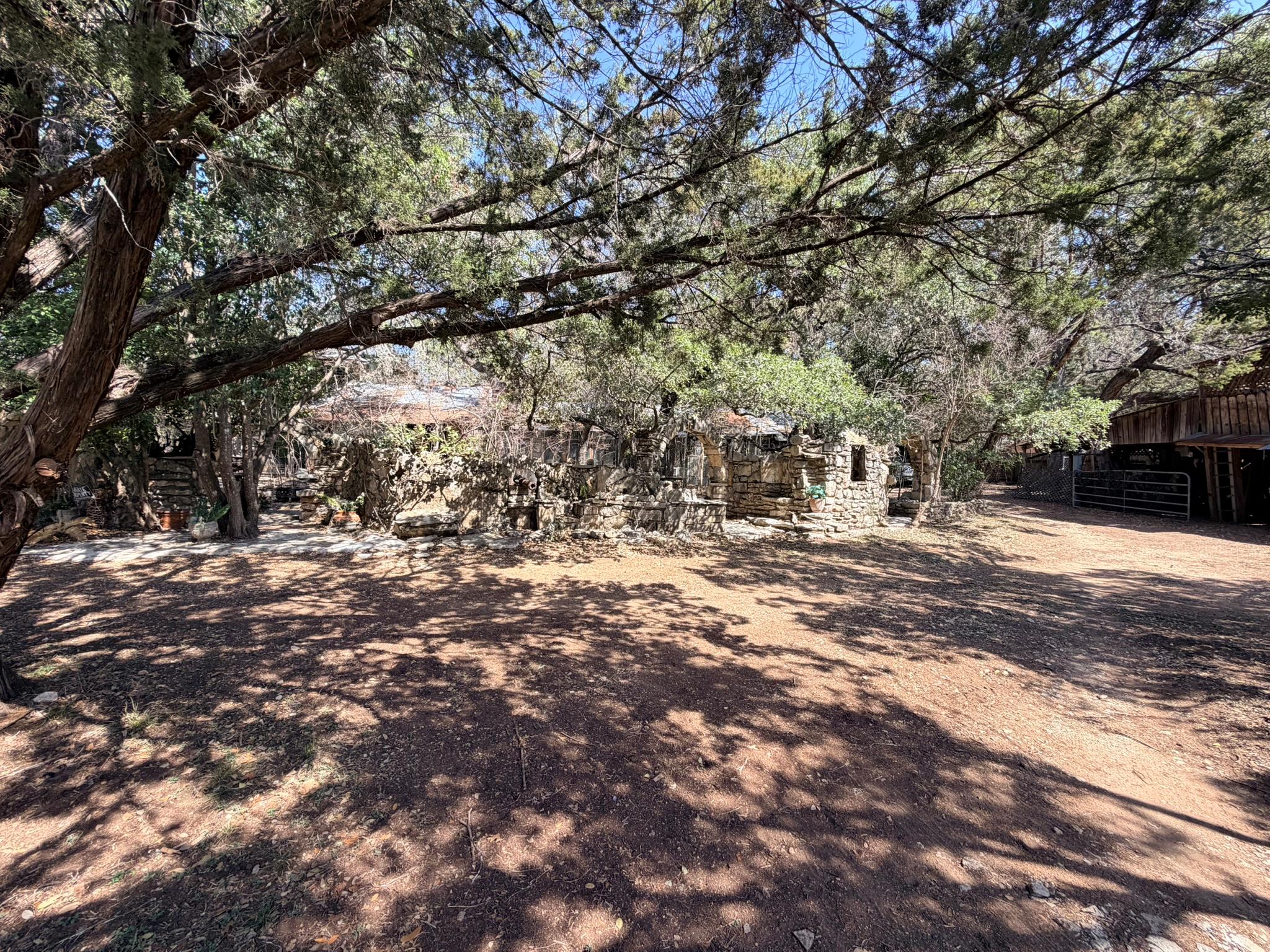 Stone-clad structure surrounded by mature trees, 