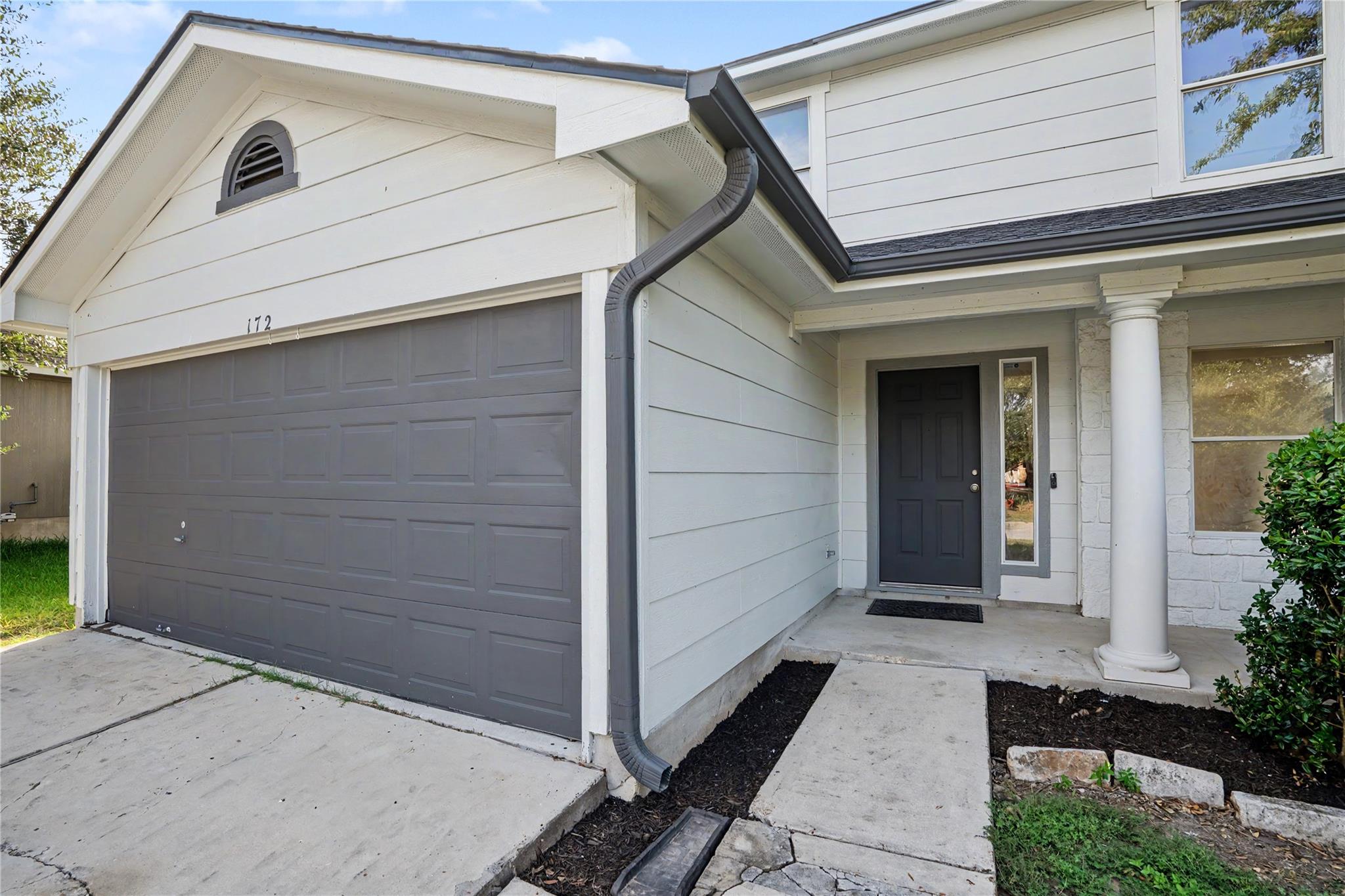 A welcoming facade showcases a gray garage door, 