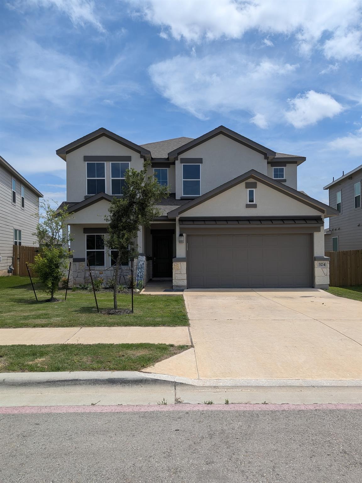 Two-story stucco and stone exterior featuring a t