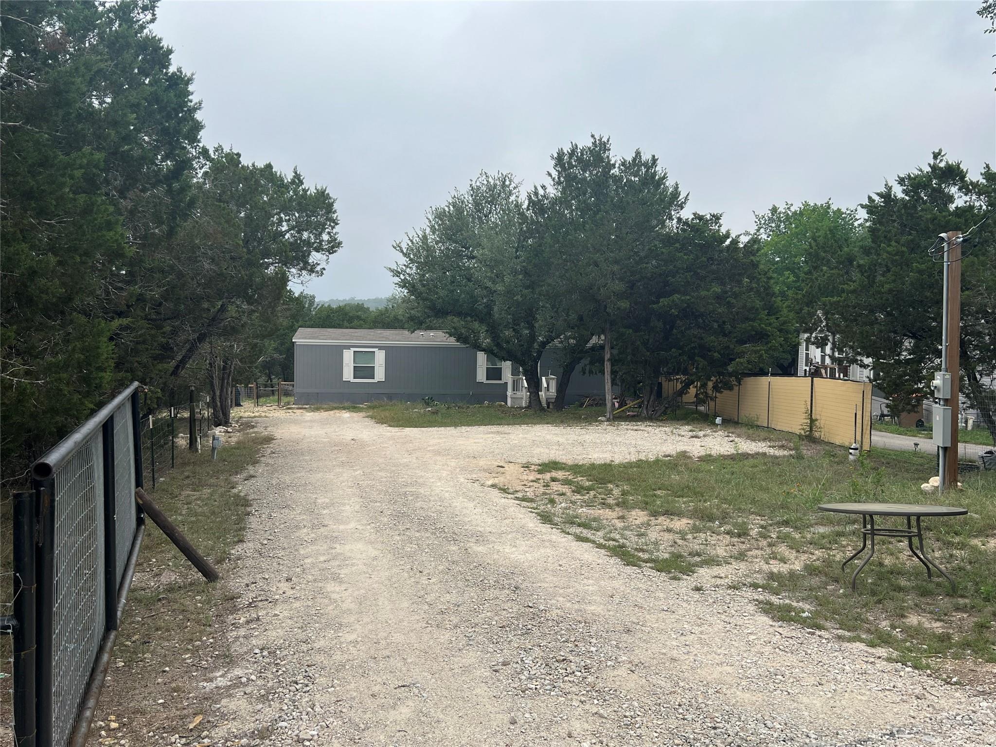 Gravel driveway leading to a grey single-story re