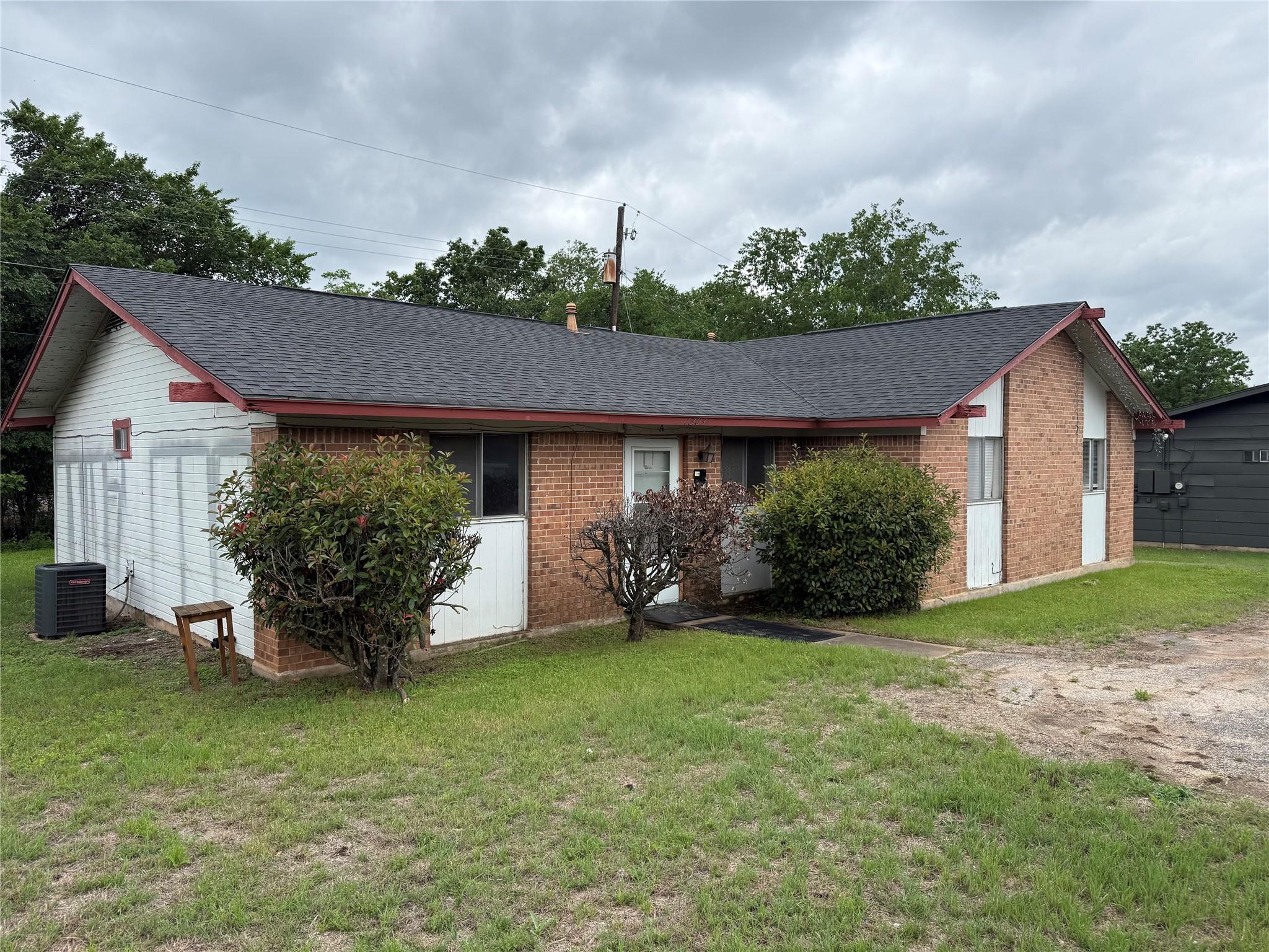 Brick and siding exterior with a dark shingle roo