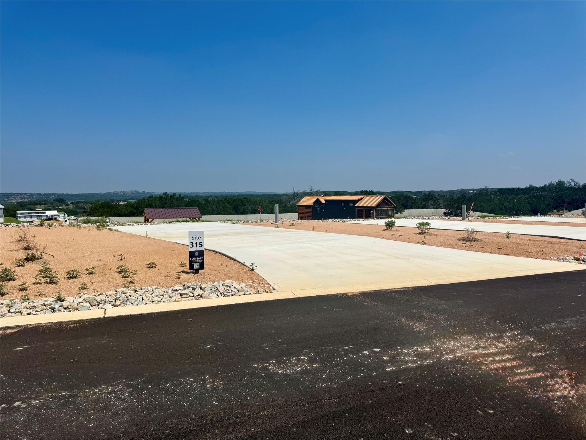 Paved lot featuring a concrete drive, surrounding