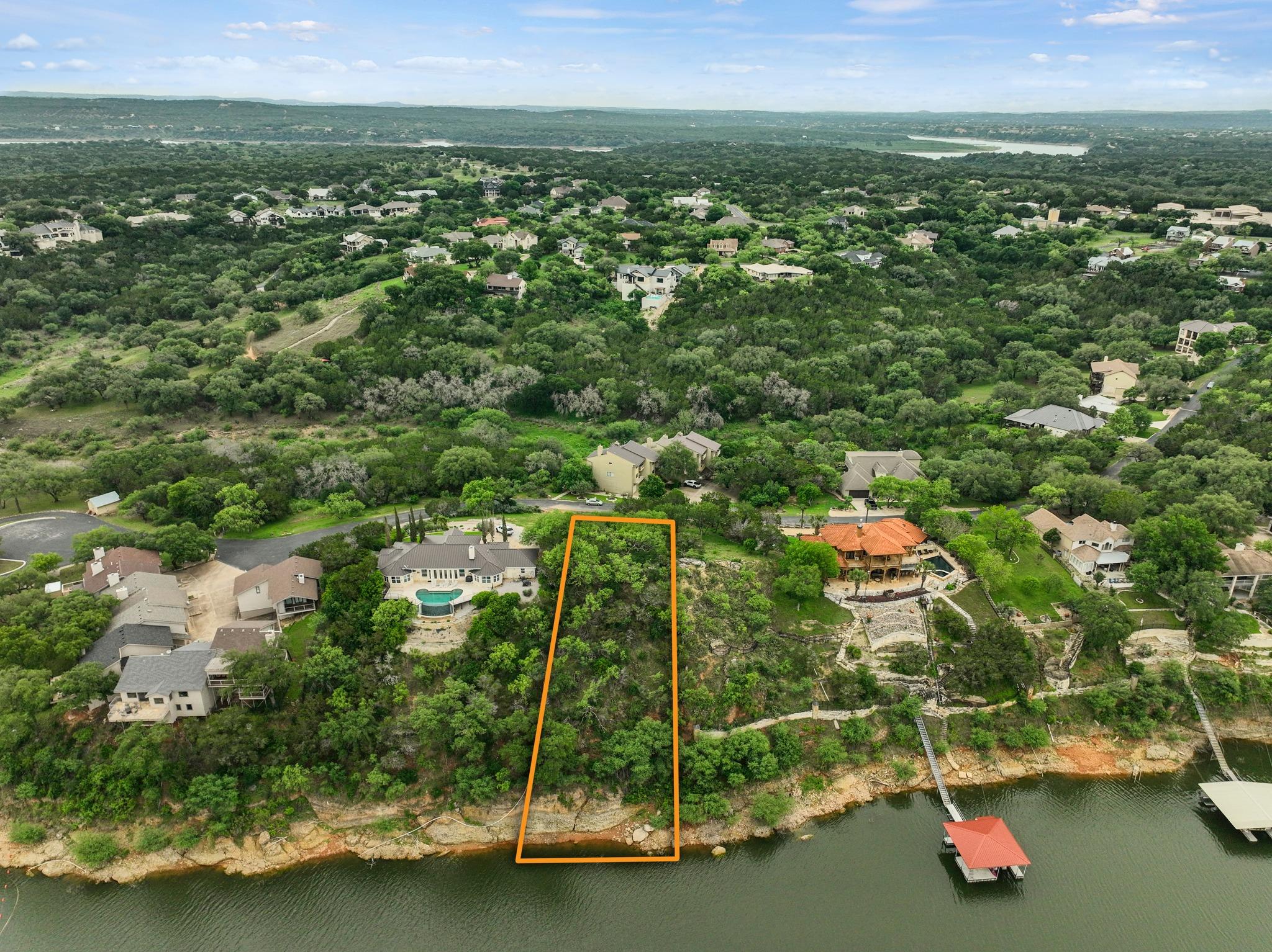 Waterfront parcel with mature trees and a sloped 