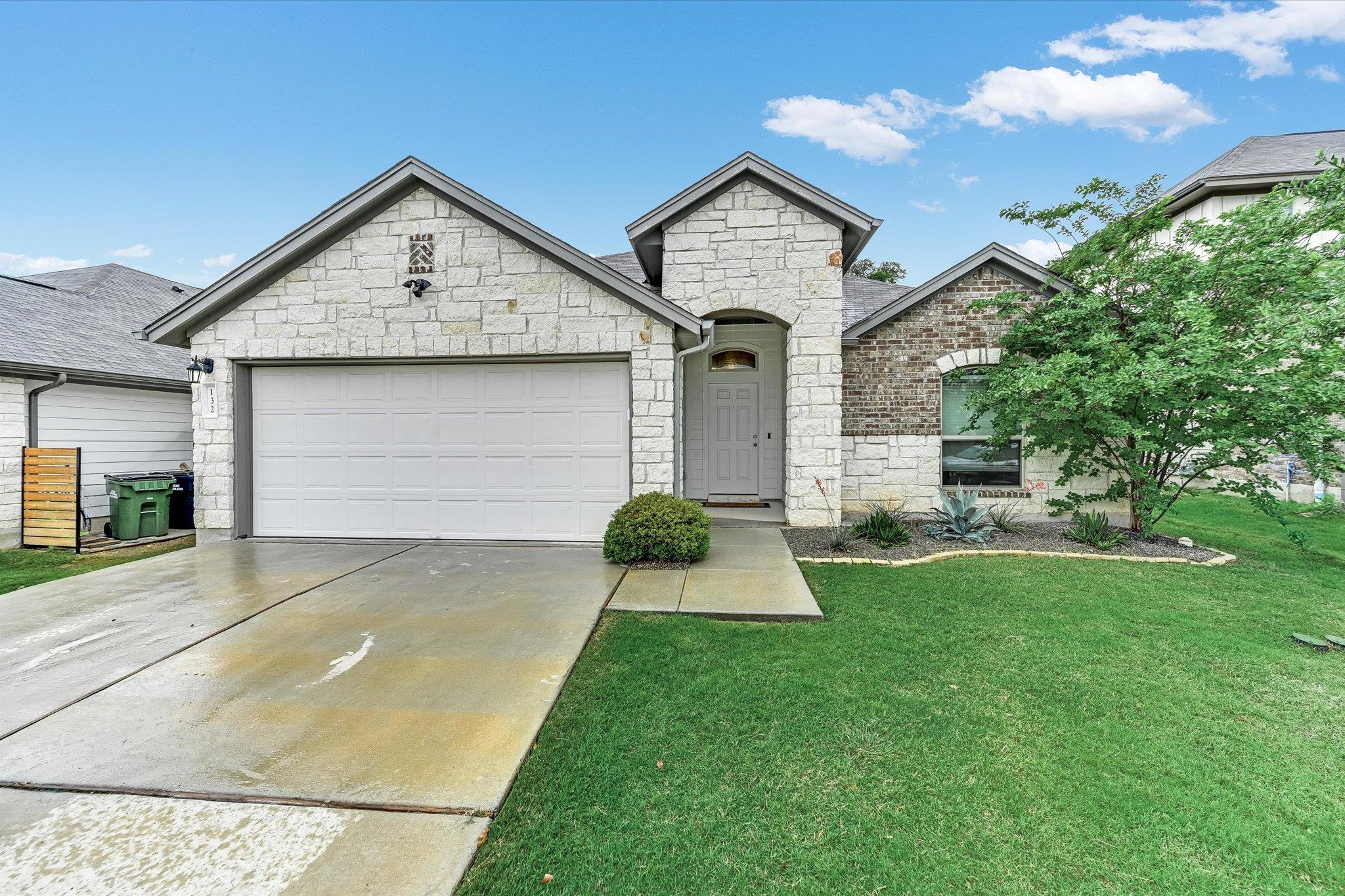 Stone and brick facade home featuring an attached