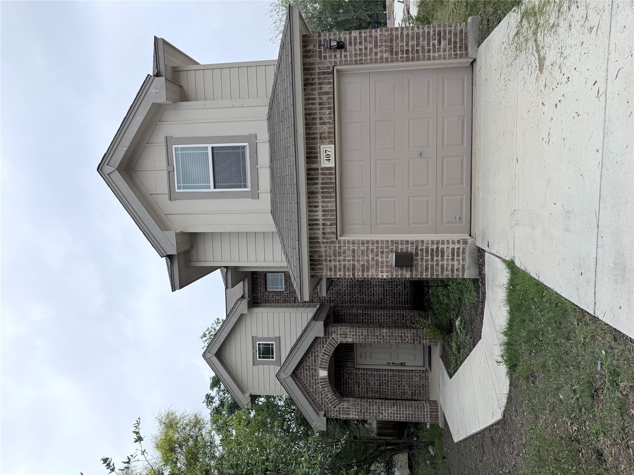 Two-story residence featuring a brick and siding 