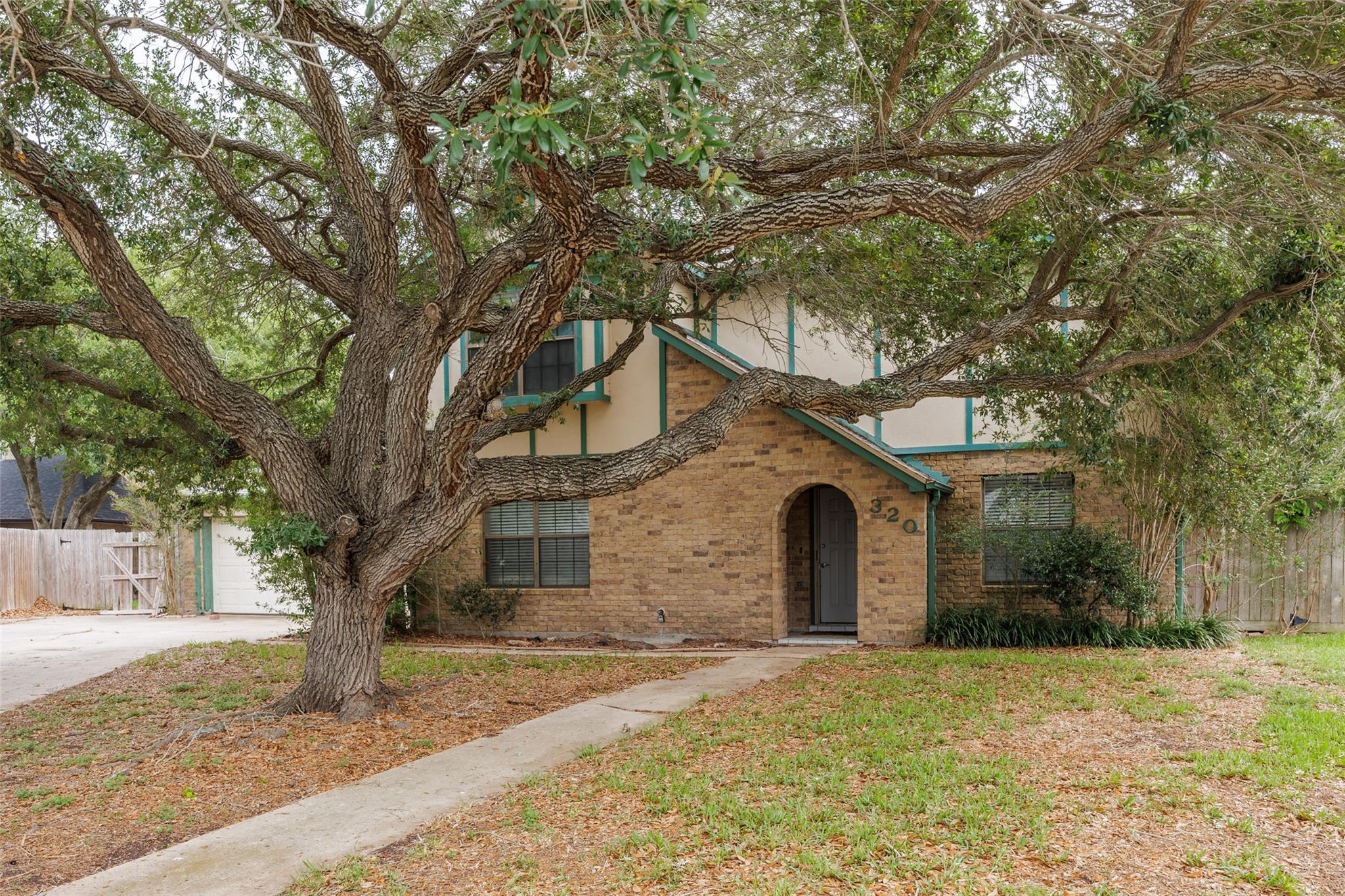 Stone facade residence featuring an arched entry,