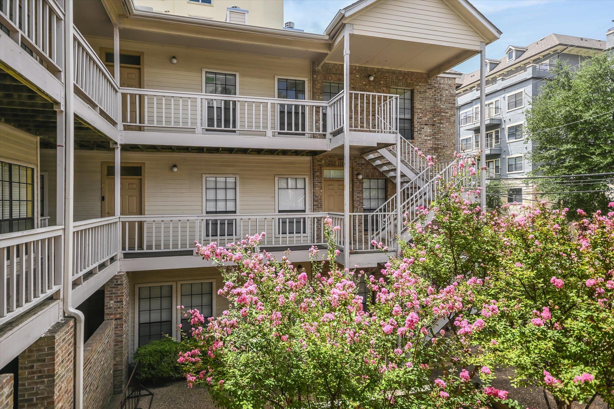 Multi-level outdoor corridors overlook a quiet br