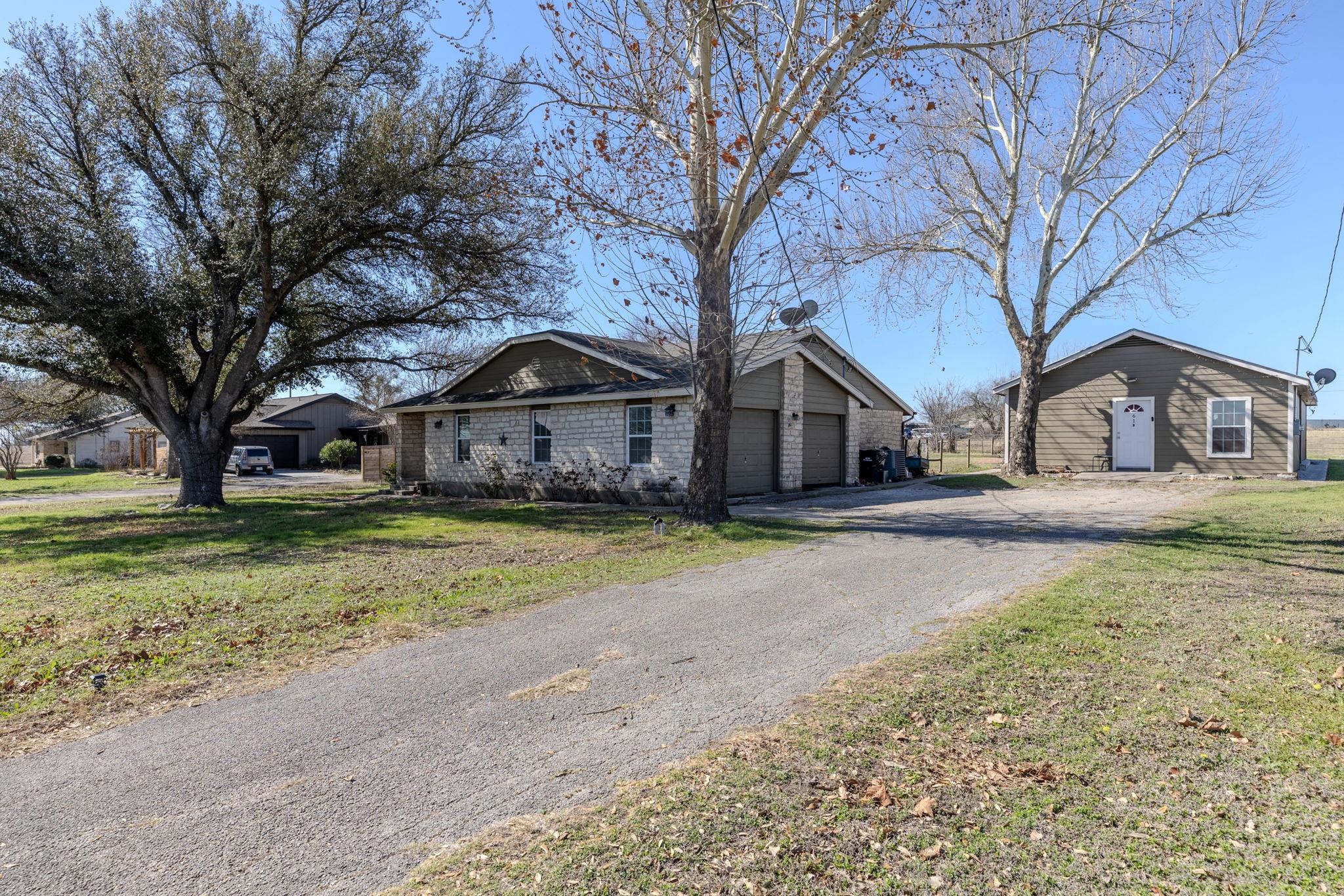 Exterior featuring a gravel driveway, two residen