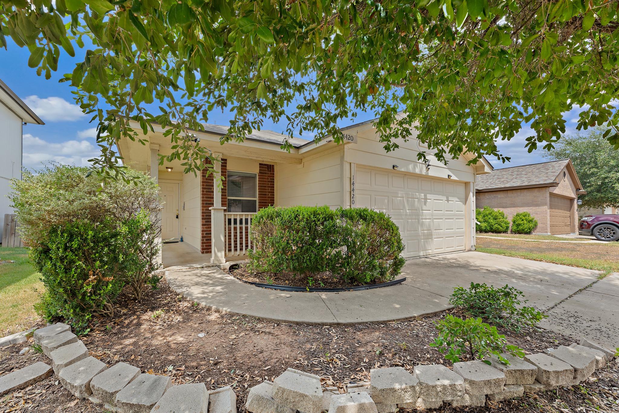 A welcoming front porch and spacious driveway enh