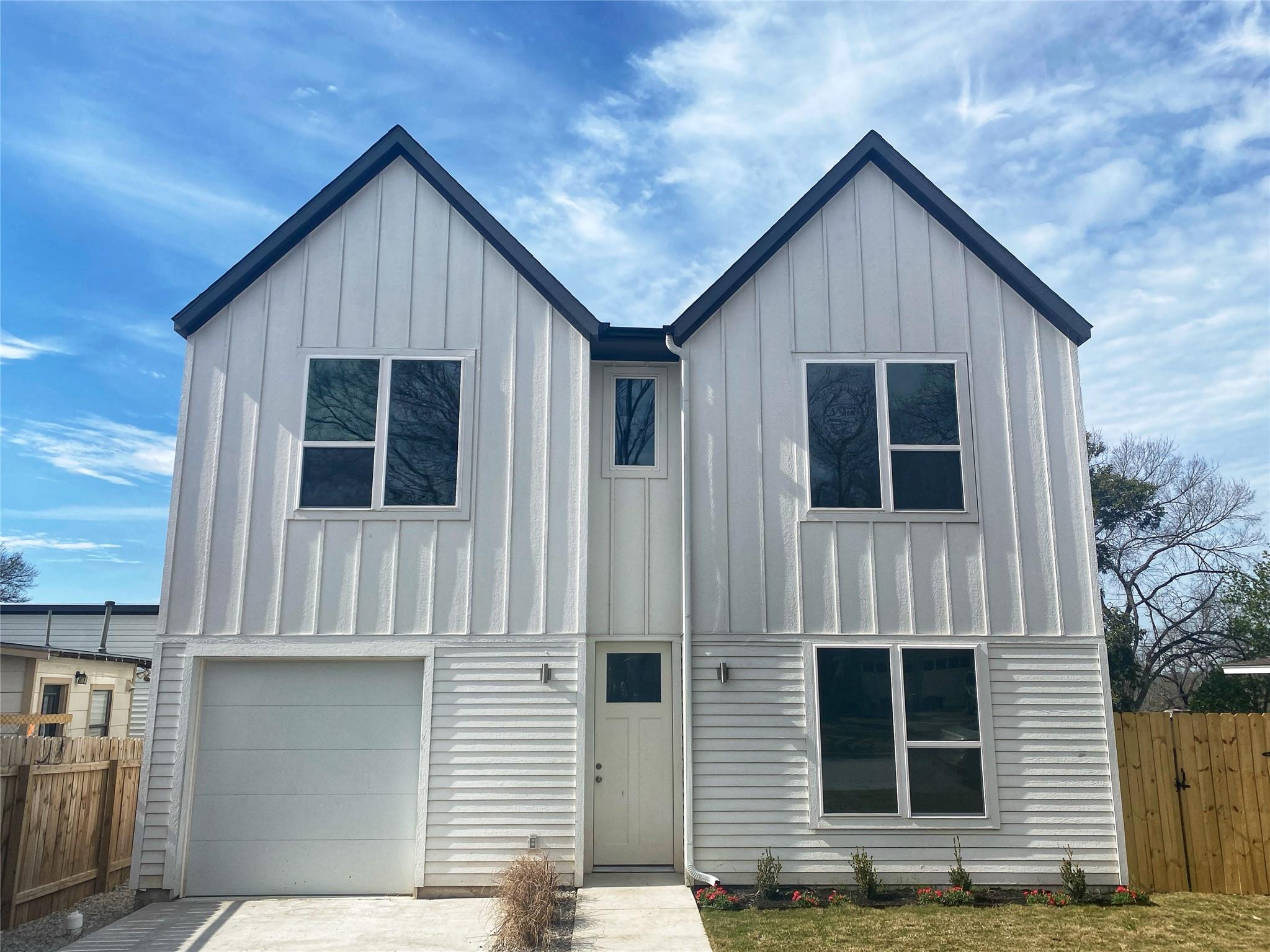 Modern two-story duplex featuring white vertical 