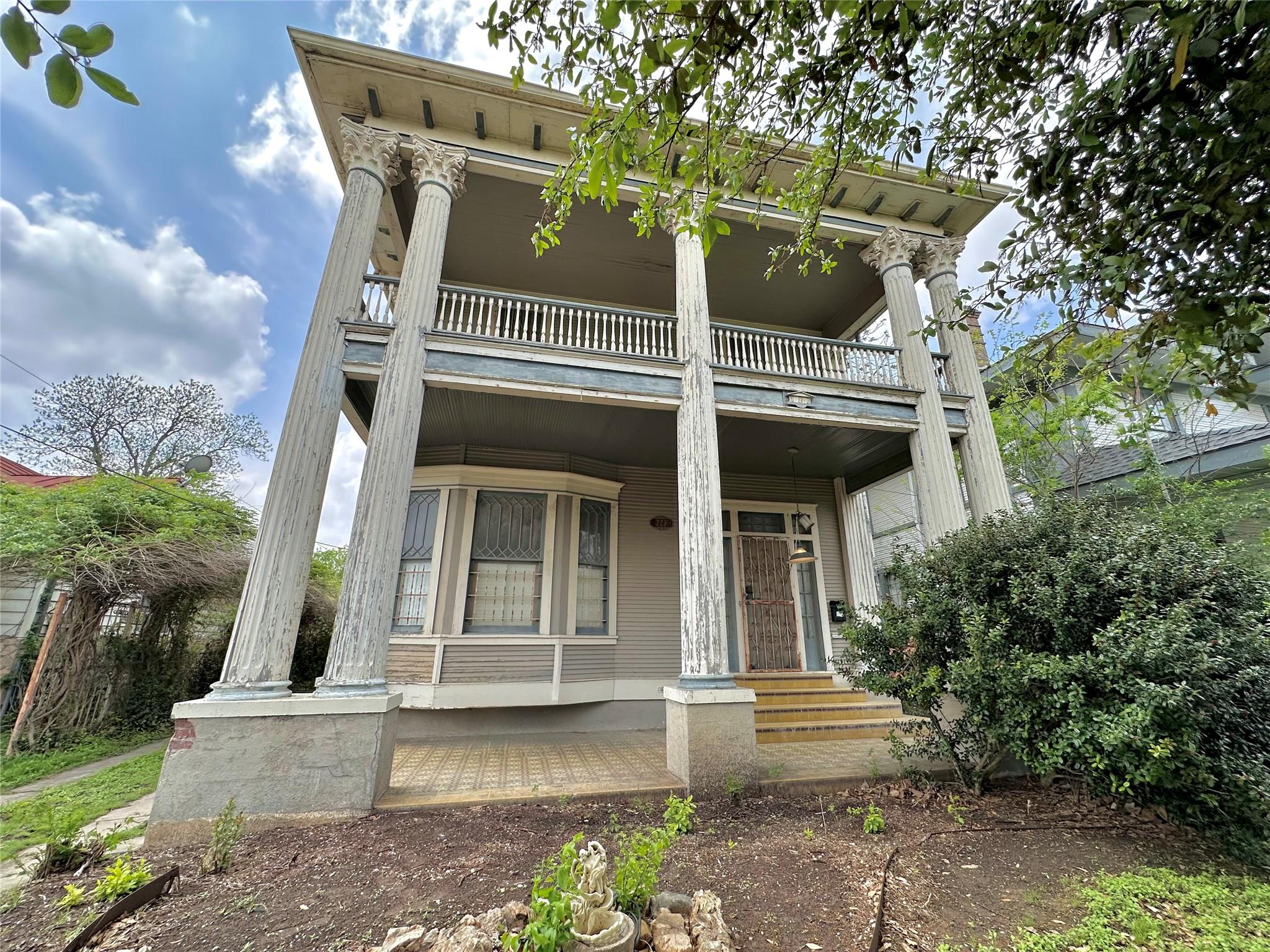 Grand facade featuring a two-story portico with f