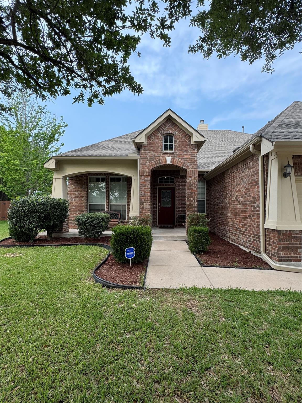Brick facade residence featuring a covered entry 