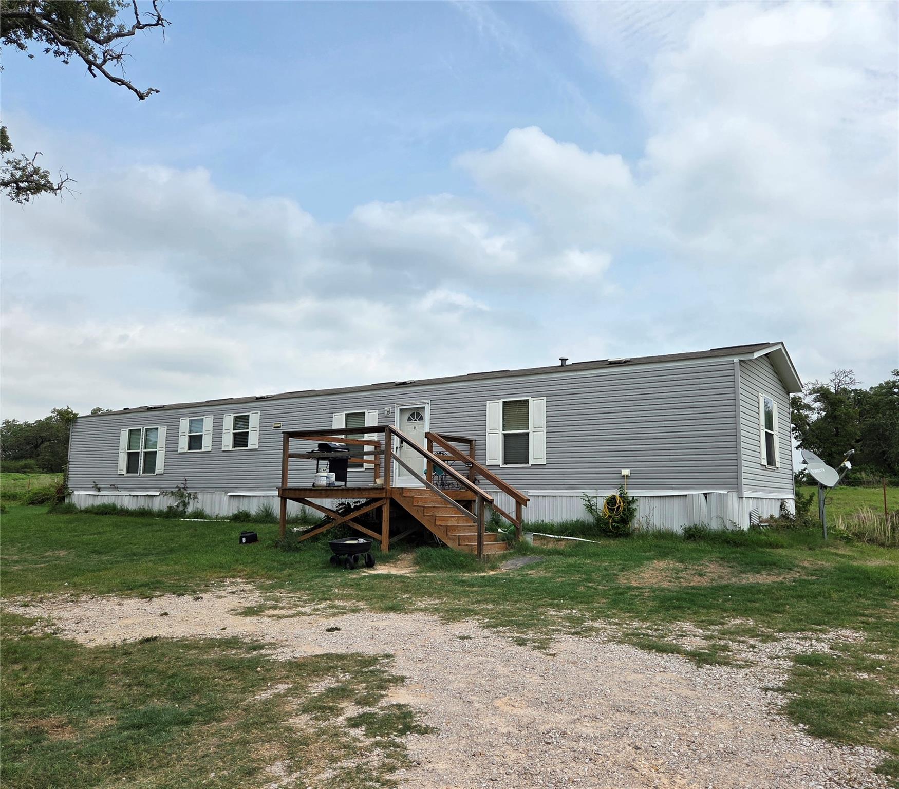 Grey siding exterior featuring white window shutt