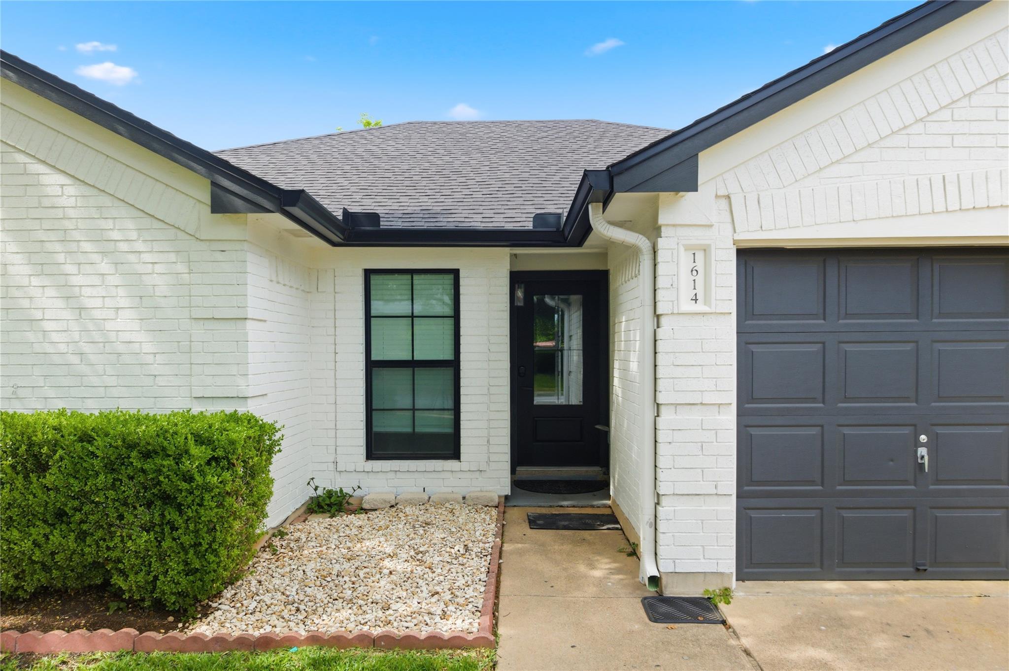 Brick exterior with a dark shingle roof, contrast