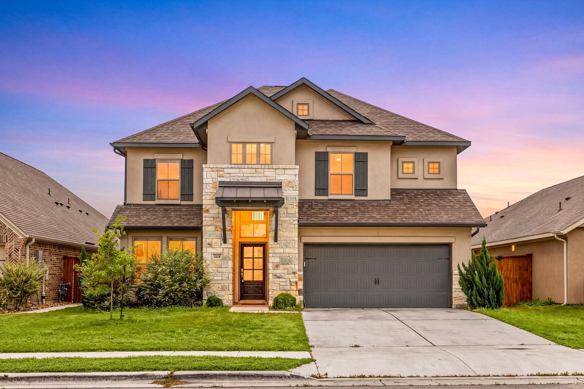Two-story residence featuring a stone and stucco 