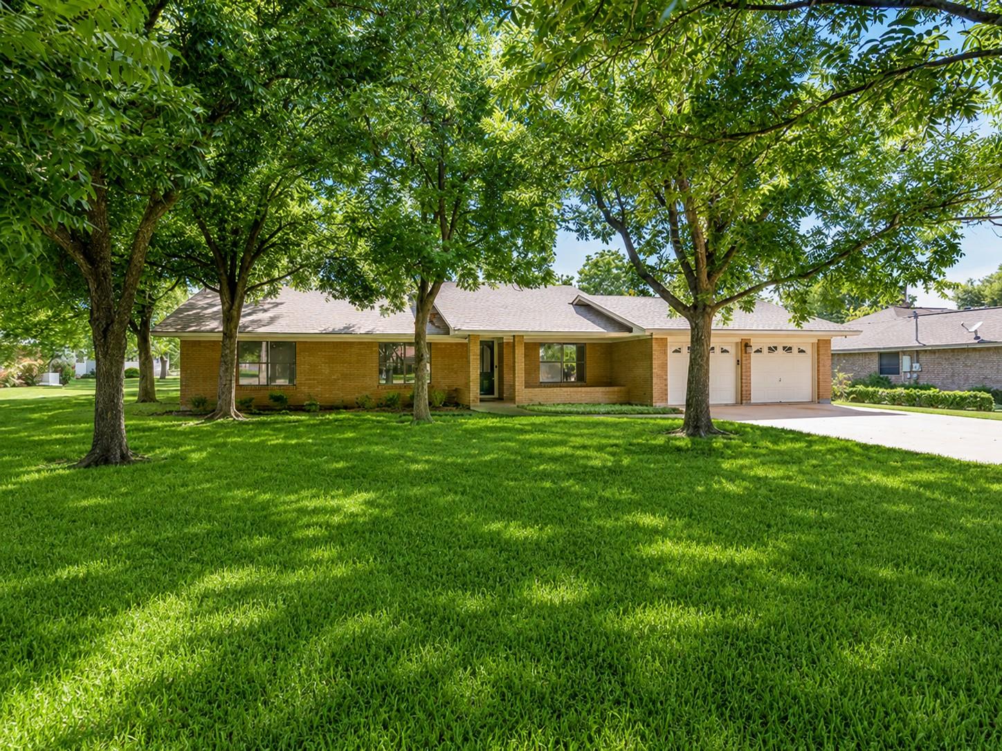Mature trees shade a charming brick residence wit
