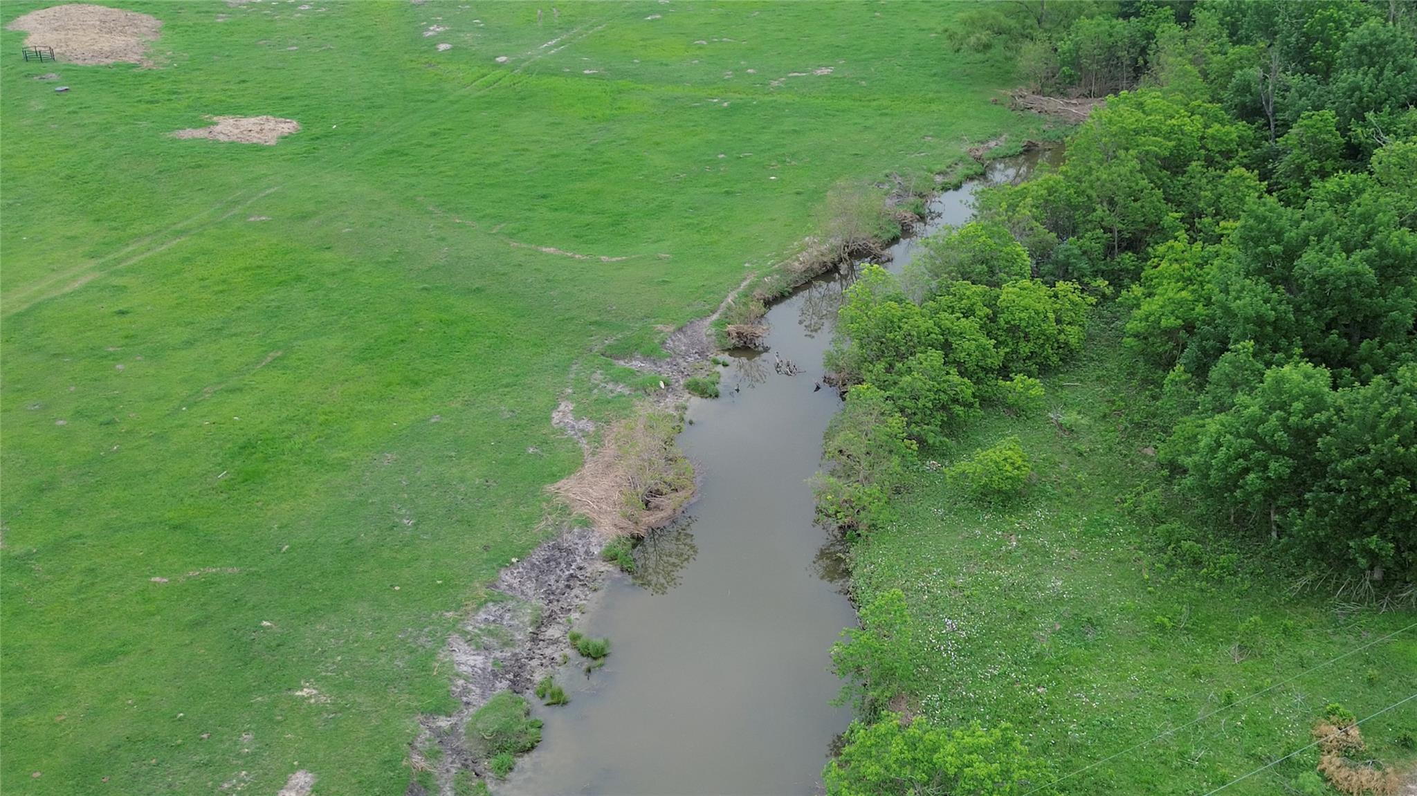 Natural waterway bordering a verdant expanse