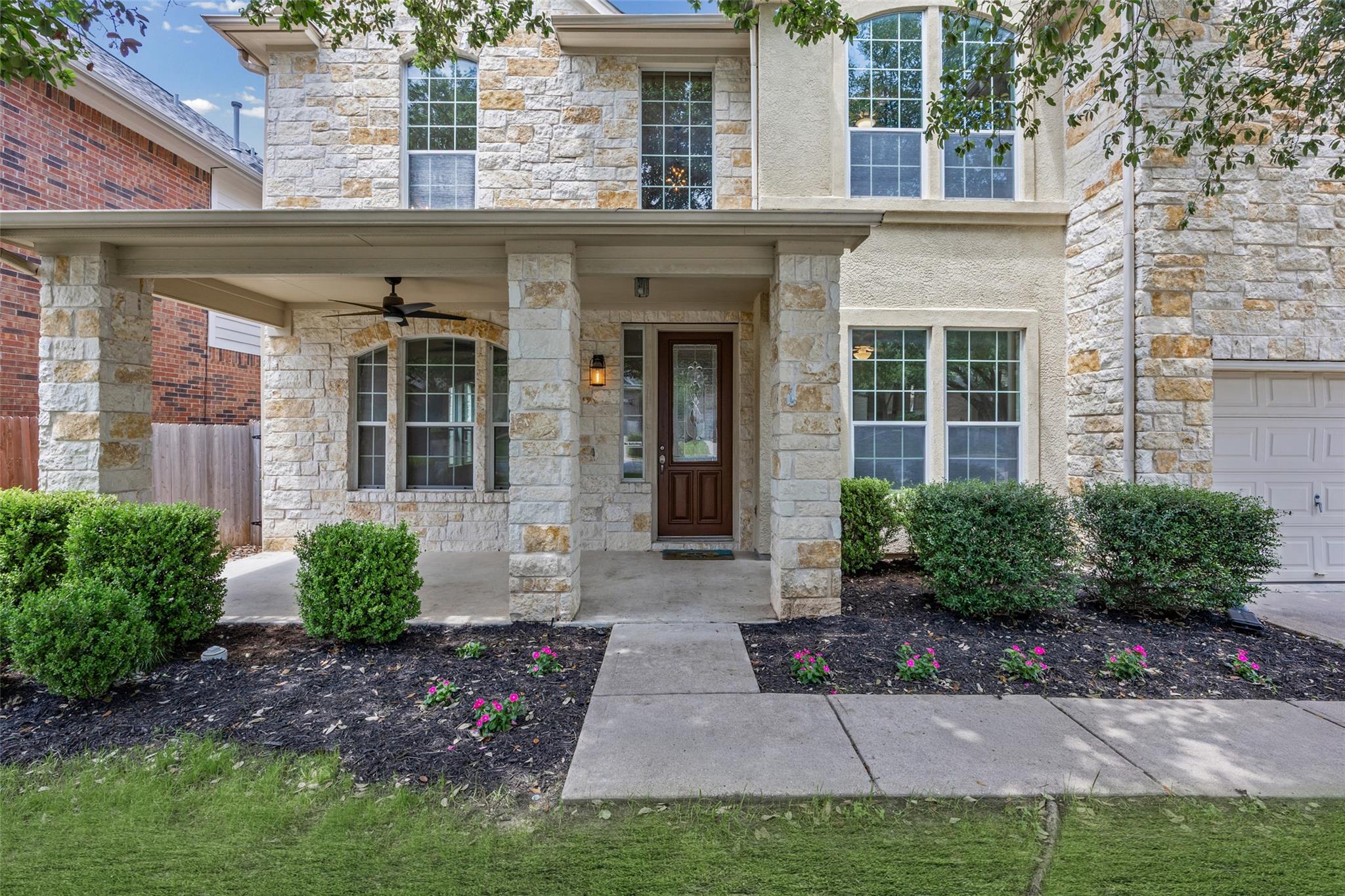 Stone and stucco exterior featuring a covered fro