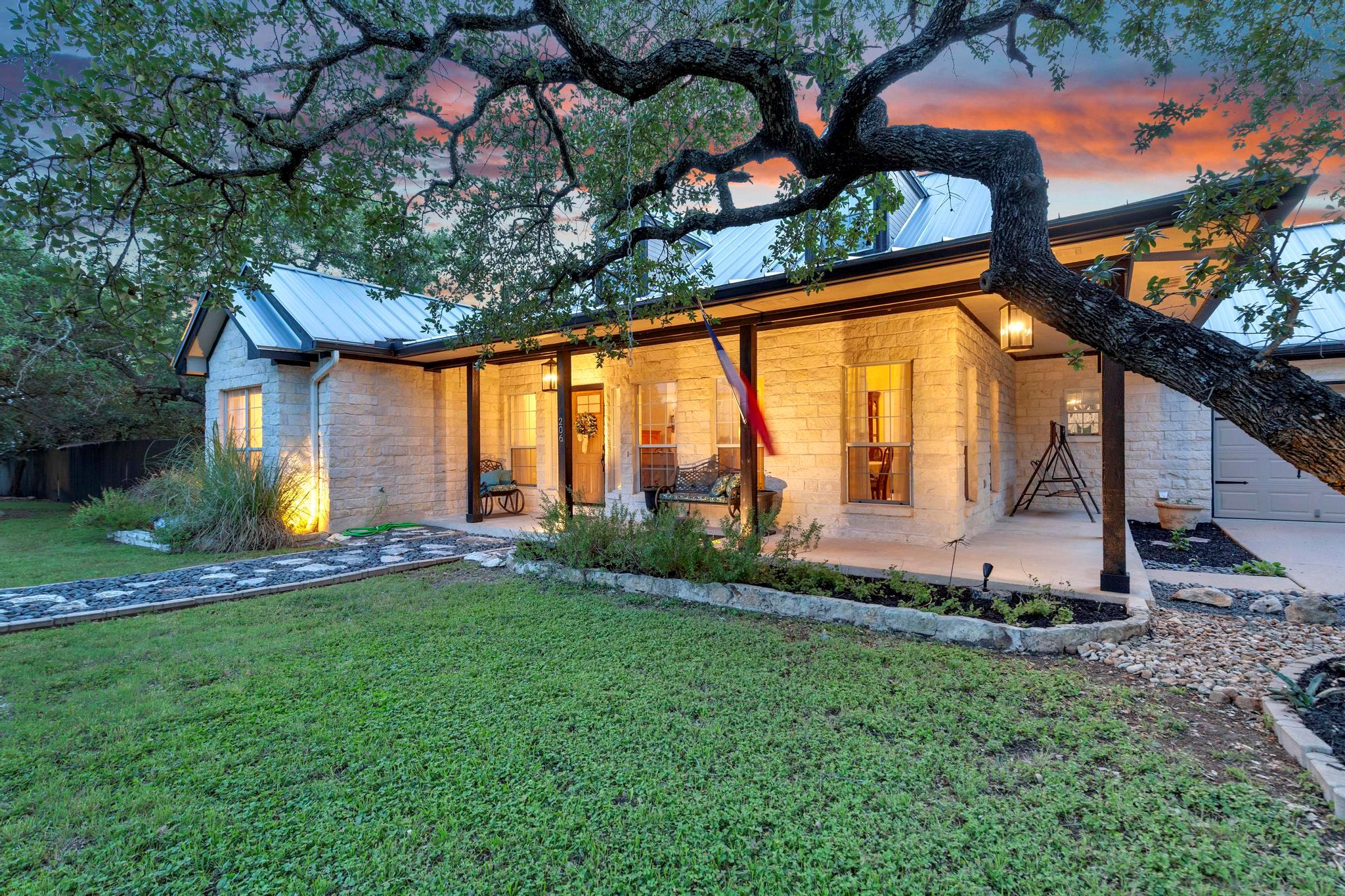 Stone exterior featuring a covered porch, metal r