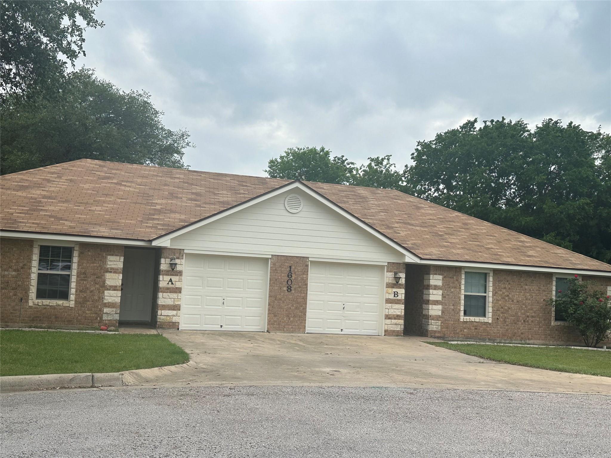 Duplex exterior featuring brick and stone veneer,