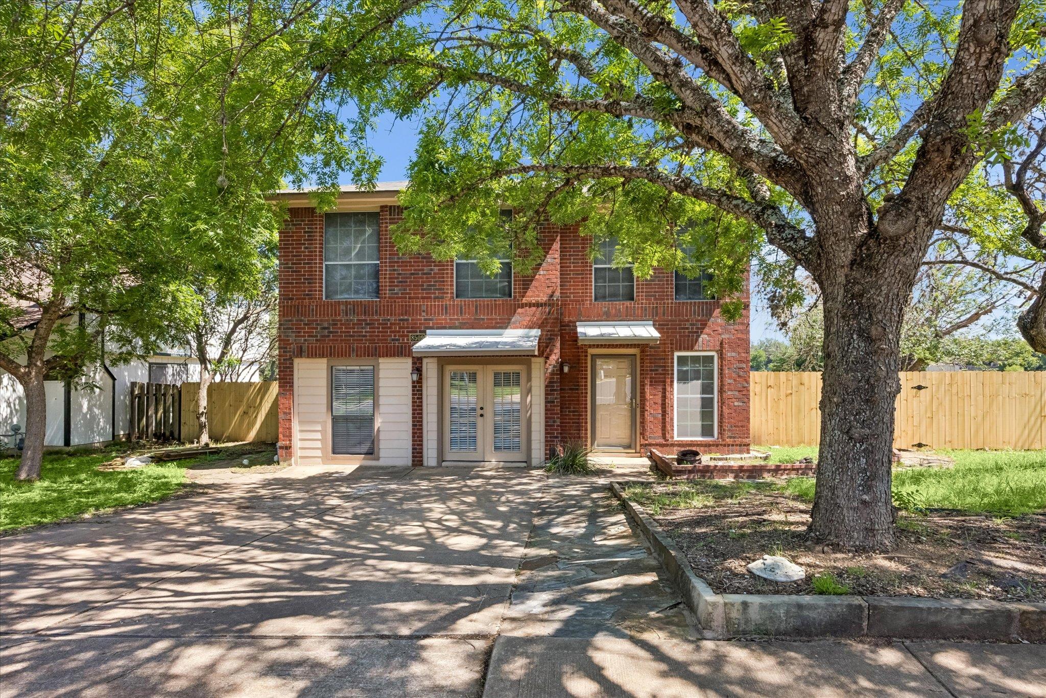 Two-story brick facade residence with multiple wi