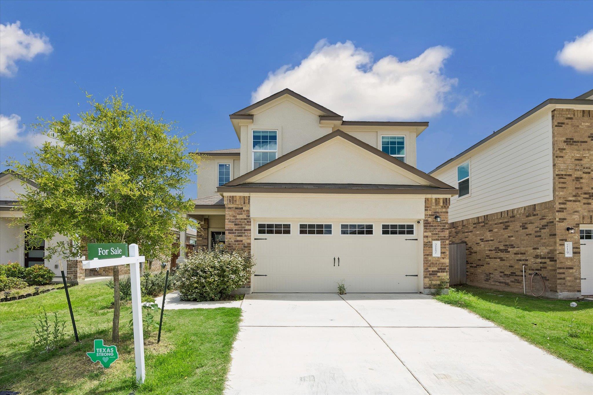 A cream-colored garage door with decorative windo
