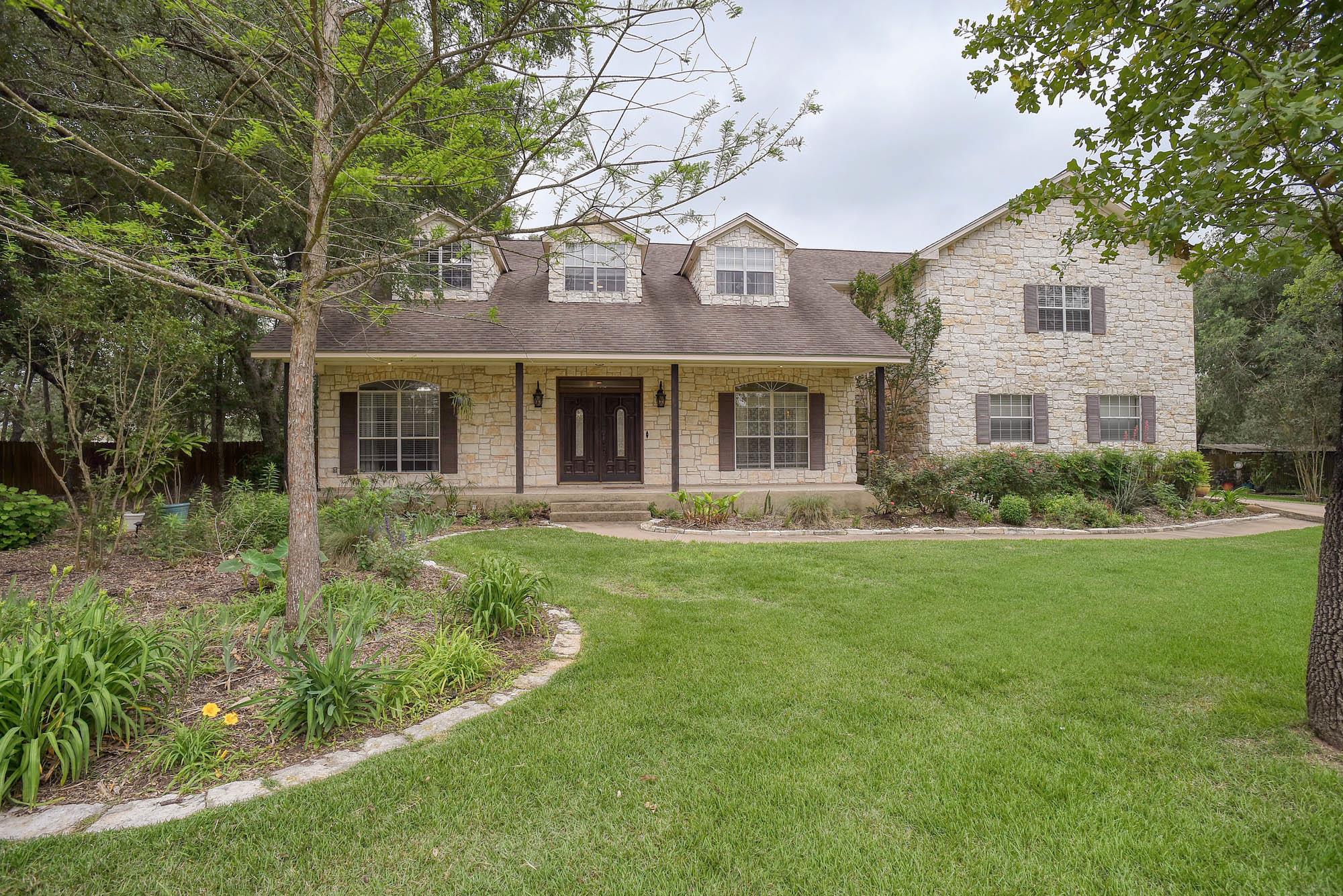 Stone-clad exterior featuring a covered front por