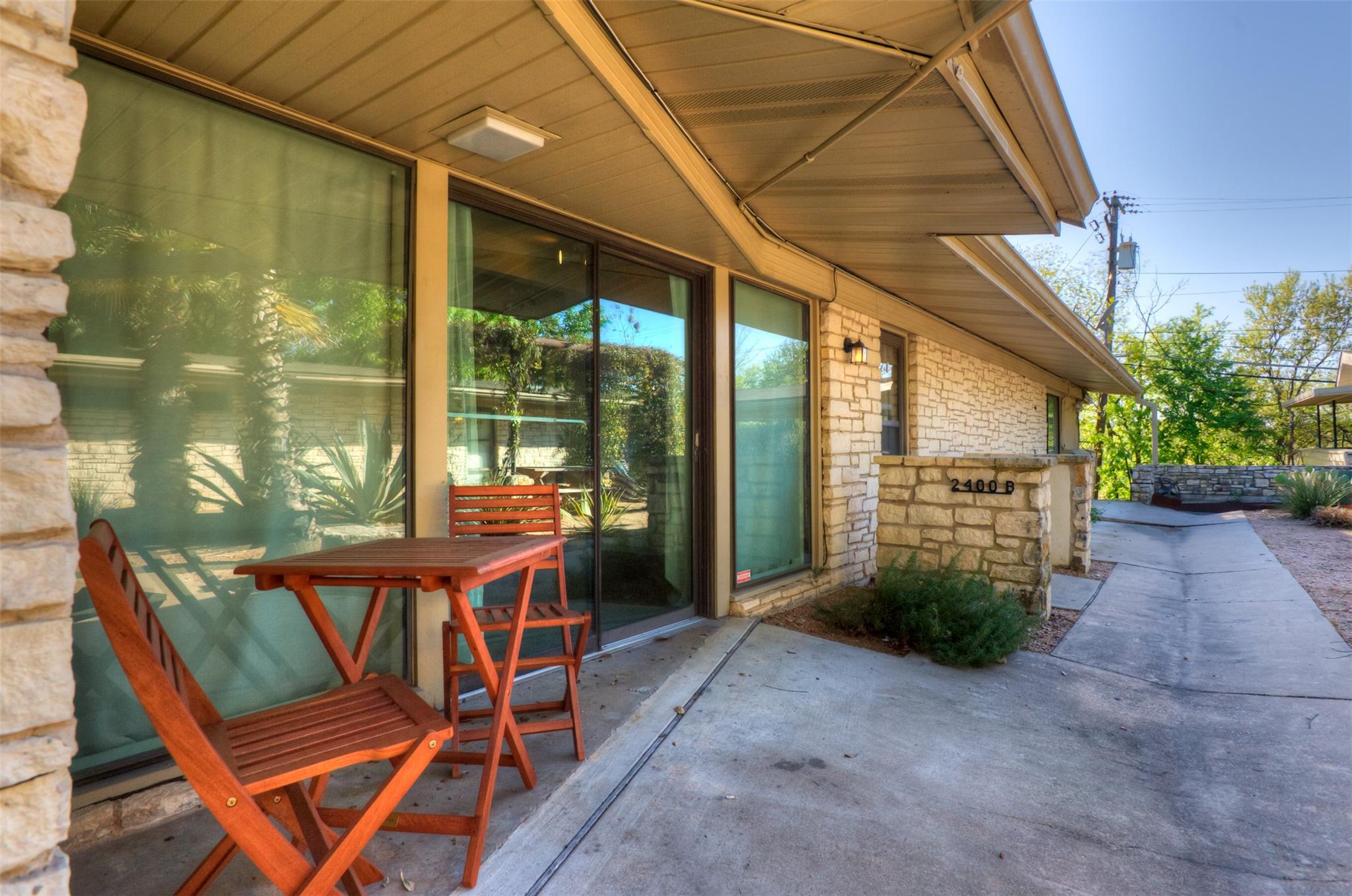Stone veneer exterior featuring large sliding gla