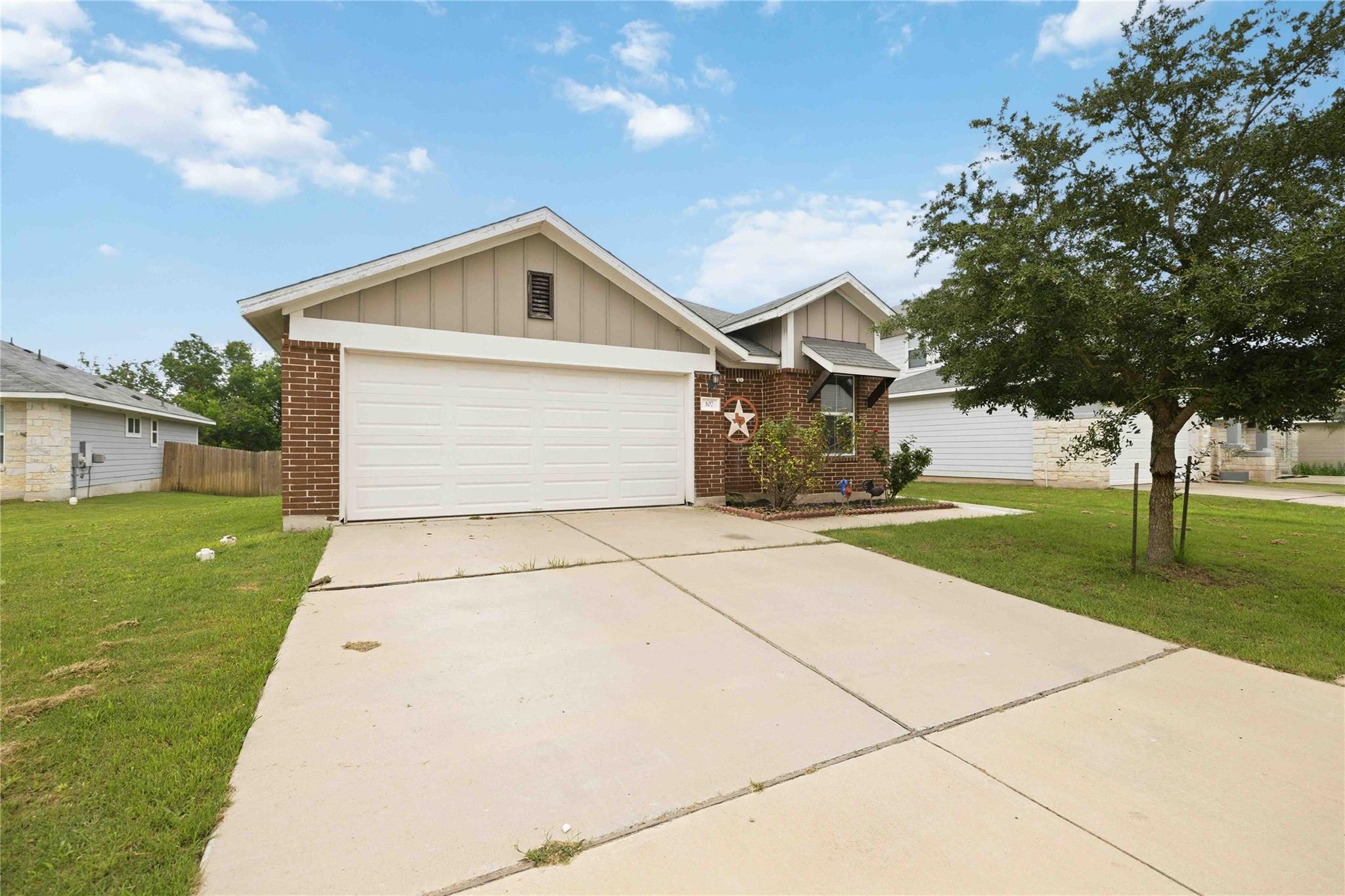 Front exterior featuring a two-car garage, brick 