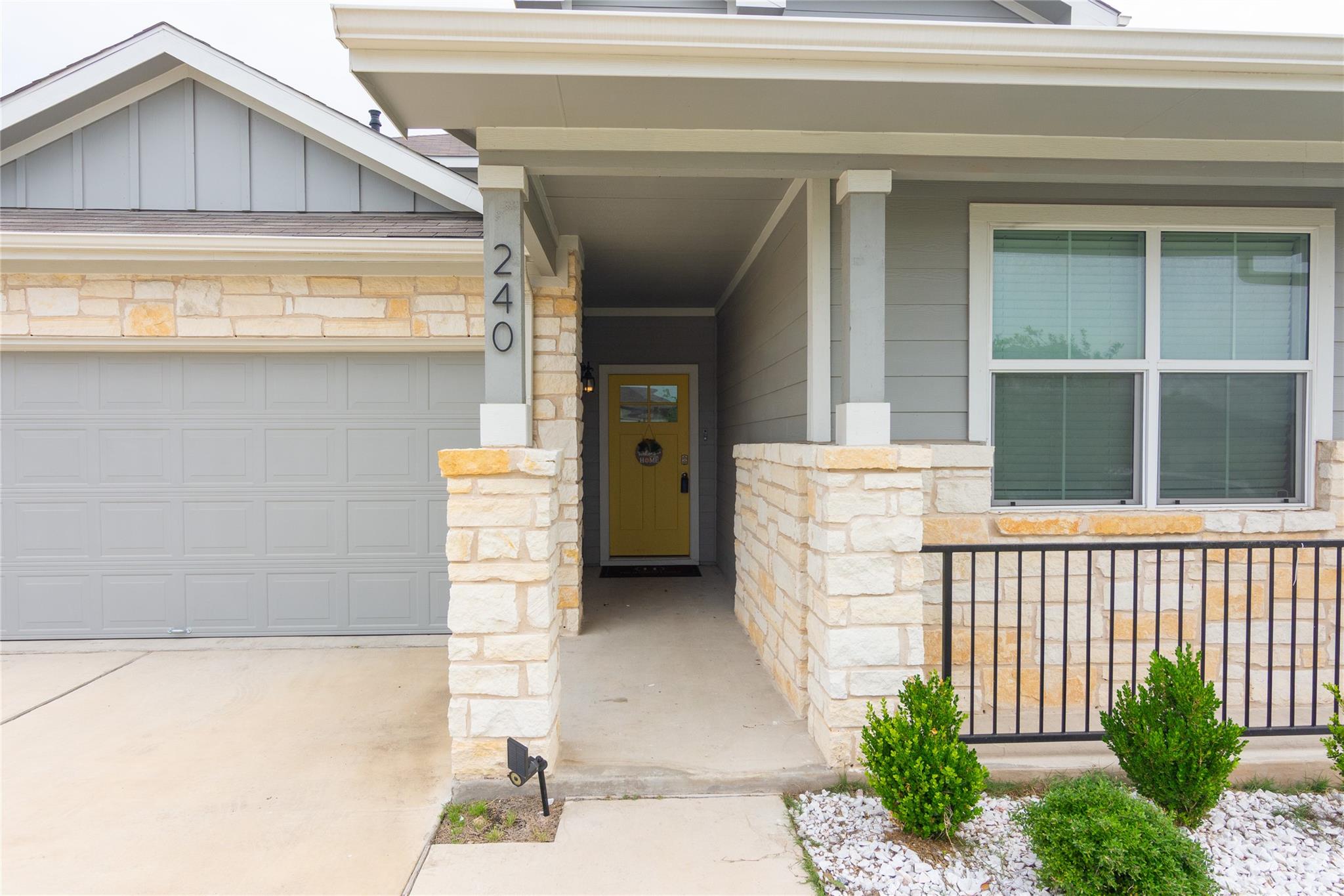 Stone and siding exterior with a bright yellow fr