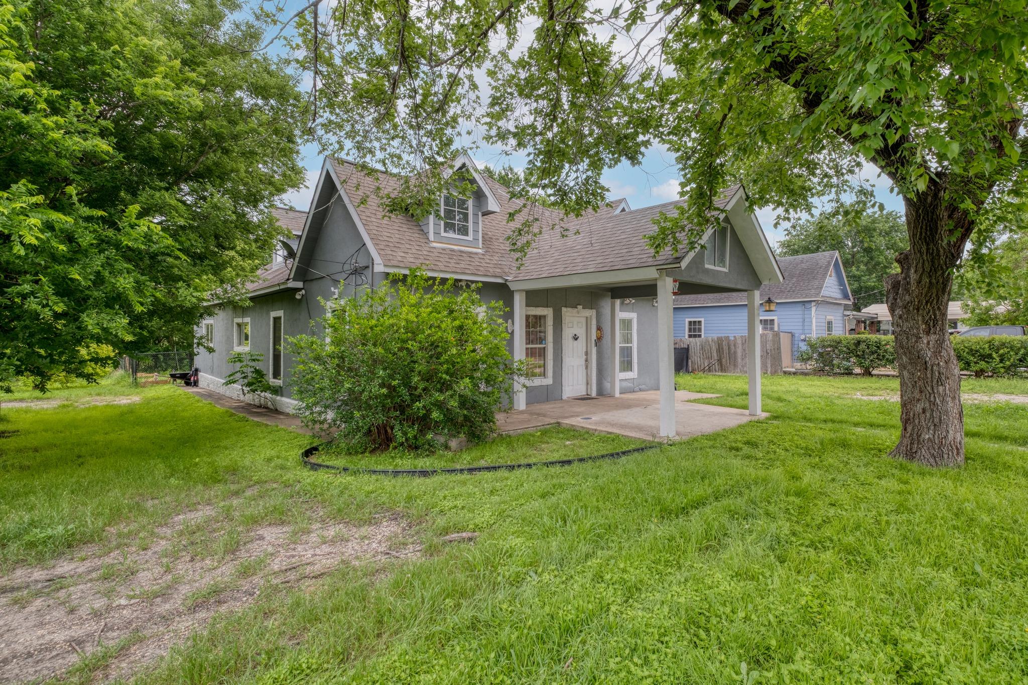 Gray exterior residence featuring a covered front