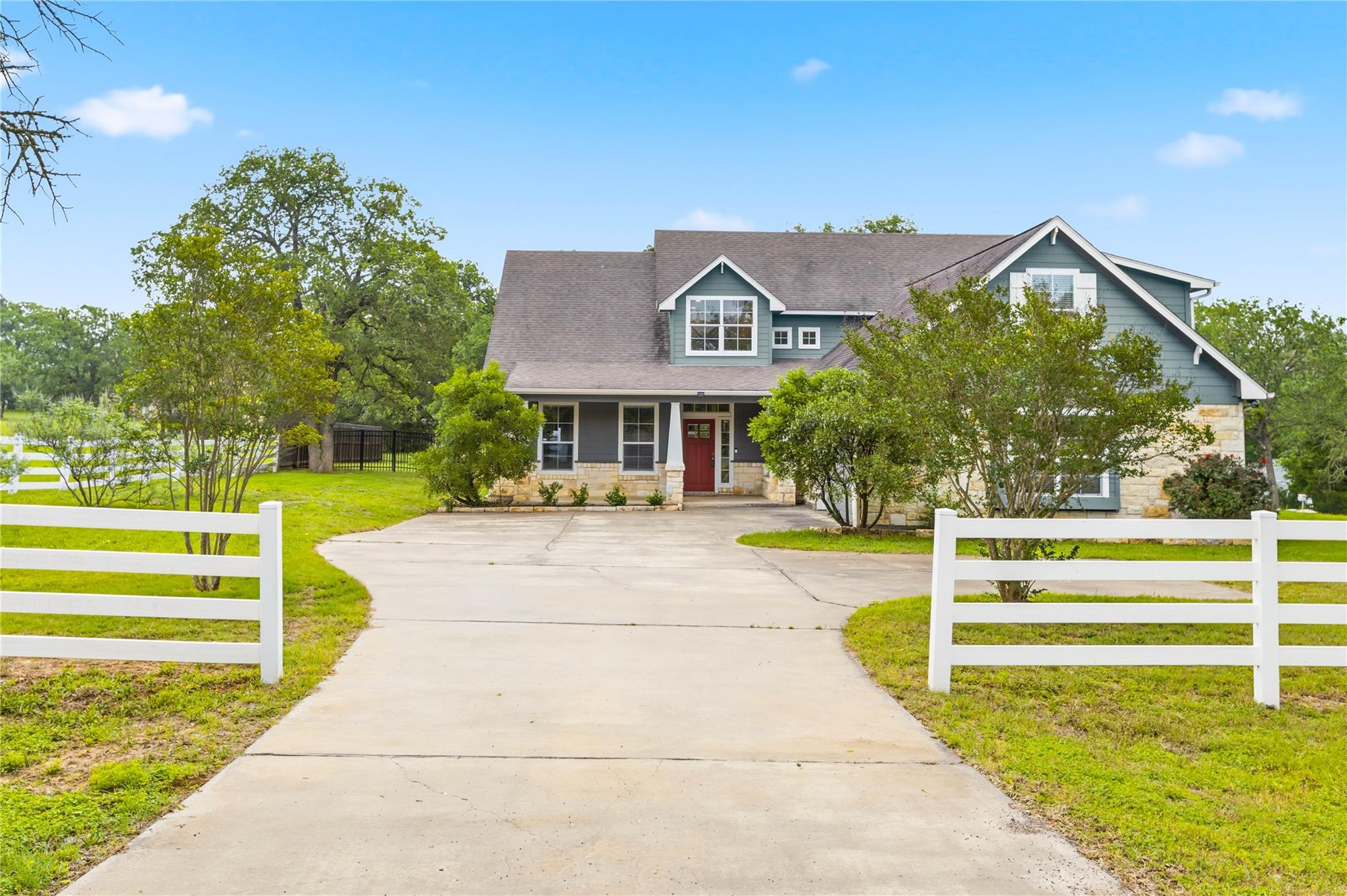 Expansive concrete driveway leading to a two-stor