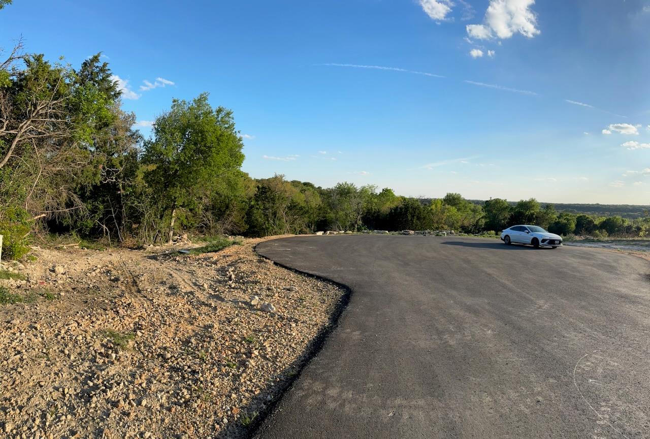 Paved drive with a curved edge, surrounded by nat
