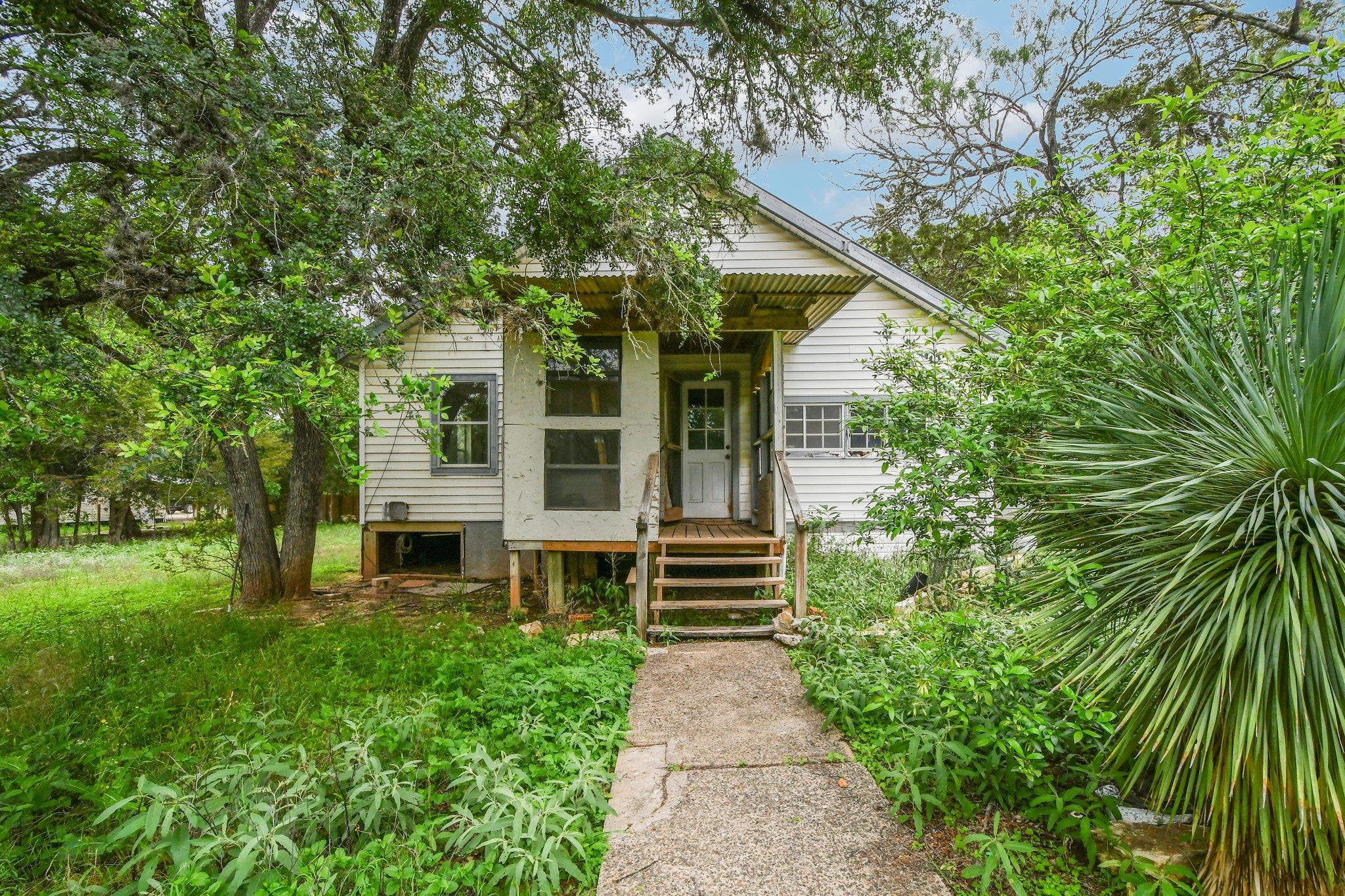 White-sided home featuring a front porch with woo