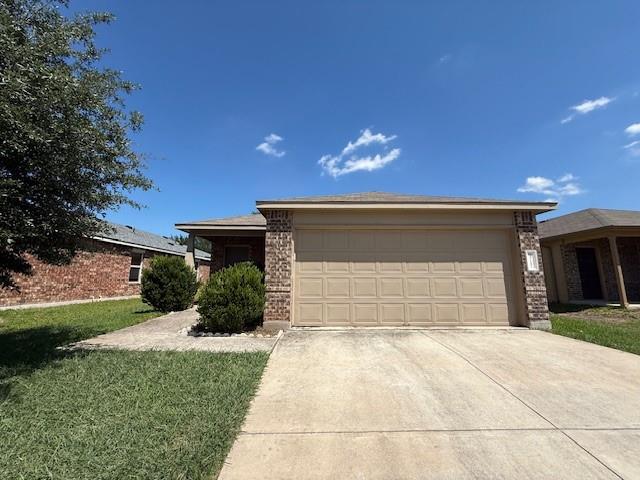 Front exterior featuring a tan garage door, brick