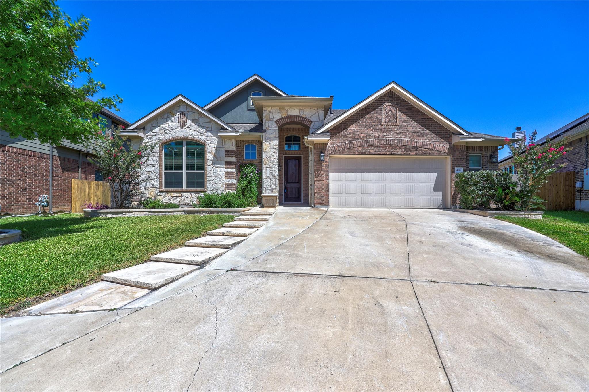 A well-kept front yard and a concrete driveway le