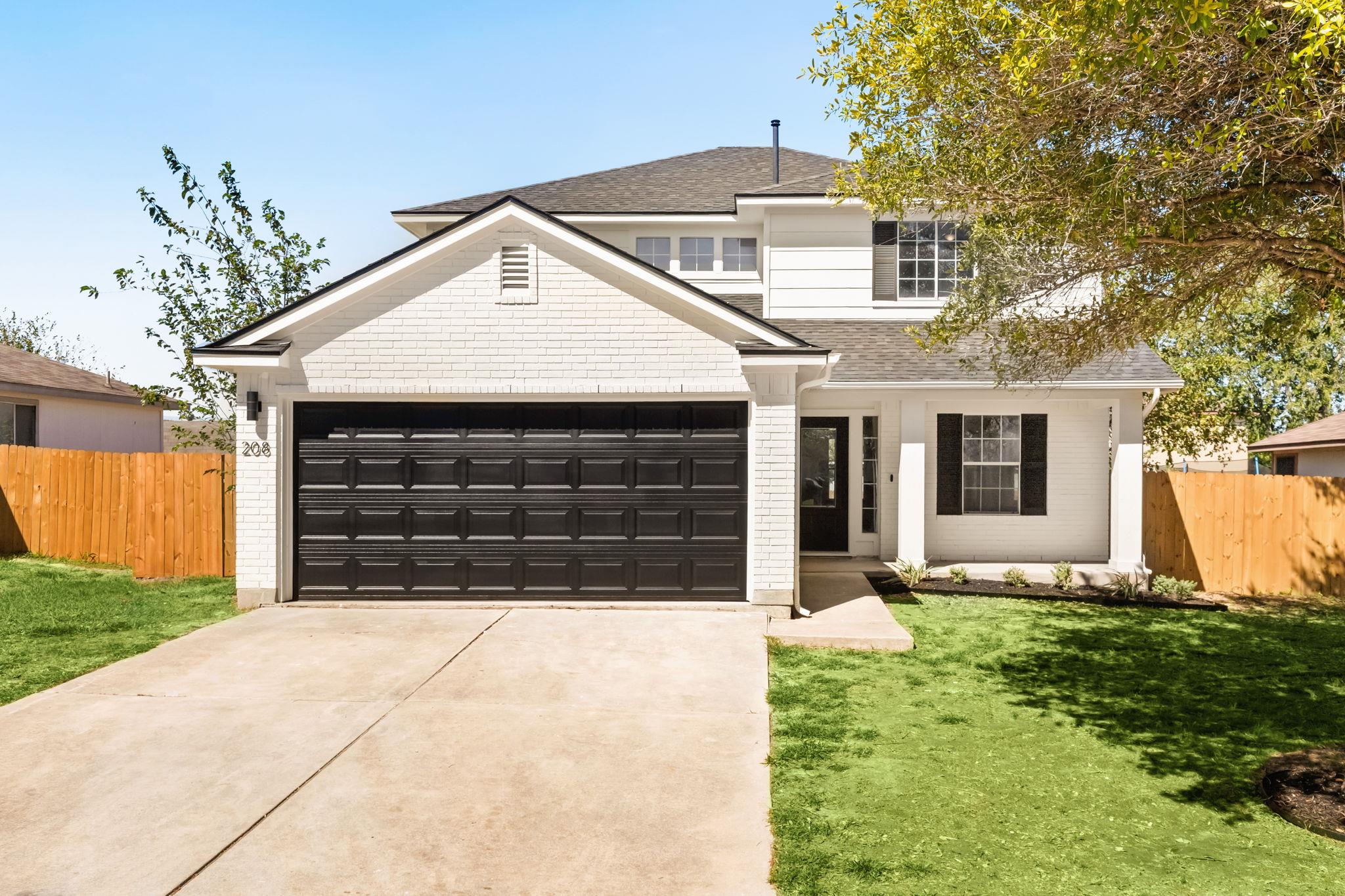 Two-story residence featuring a white brick and s