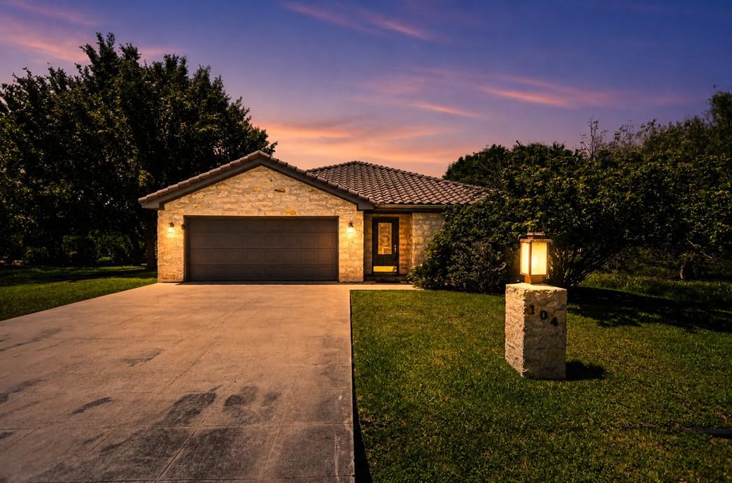 Stone facade residence featuring an attached gara