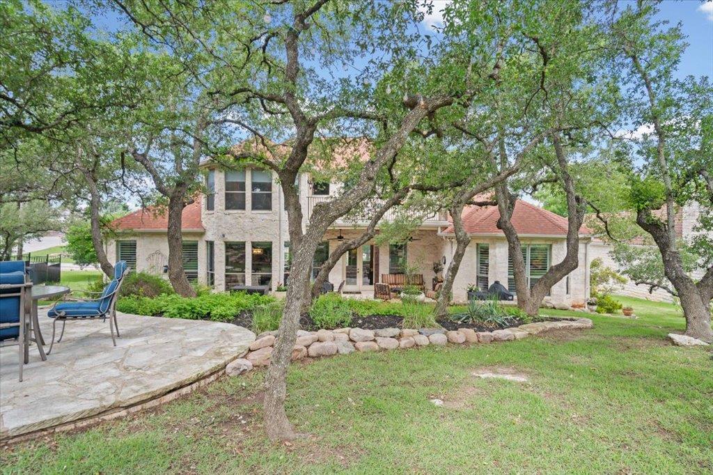 Mature shade trees frame the limestone exterior o